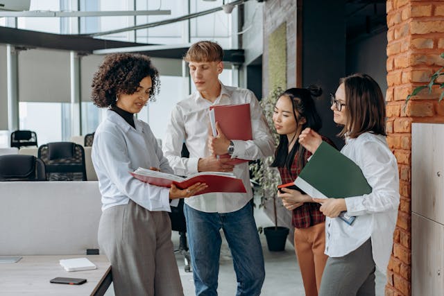 An illustrative photo of two business colleagues standing in an office, intently reading documents together