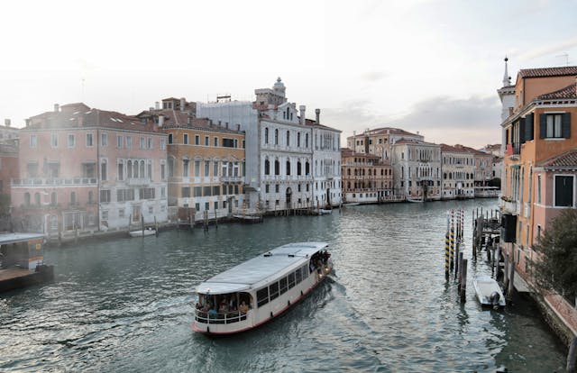 An illustrative photo of Venice waterway with old buildings and ferry