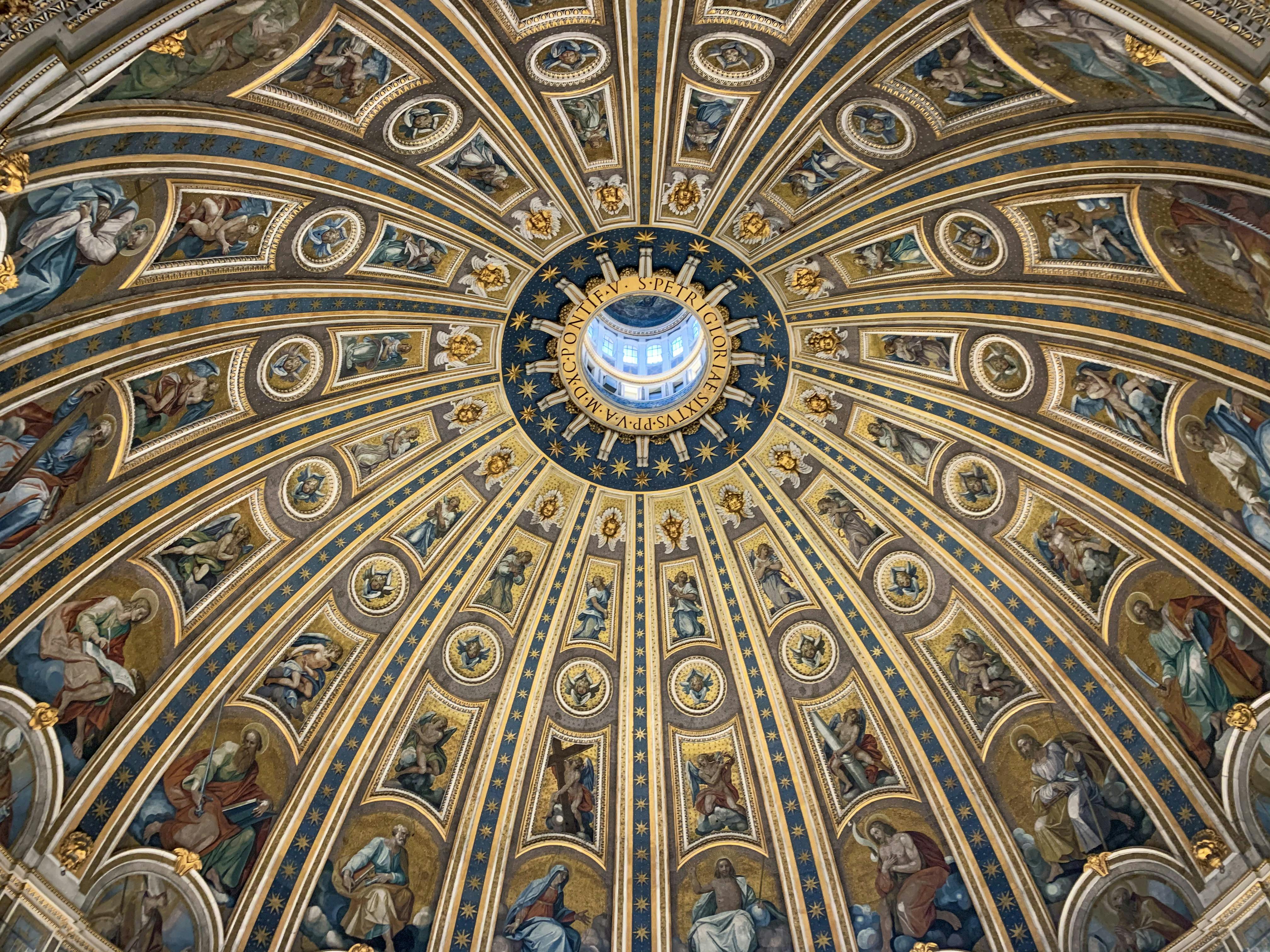 An illustrative photo of a majestic dome ceiling with fresco paintings in a Catholic cathedral