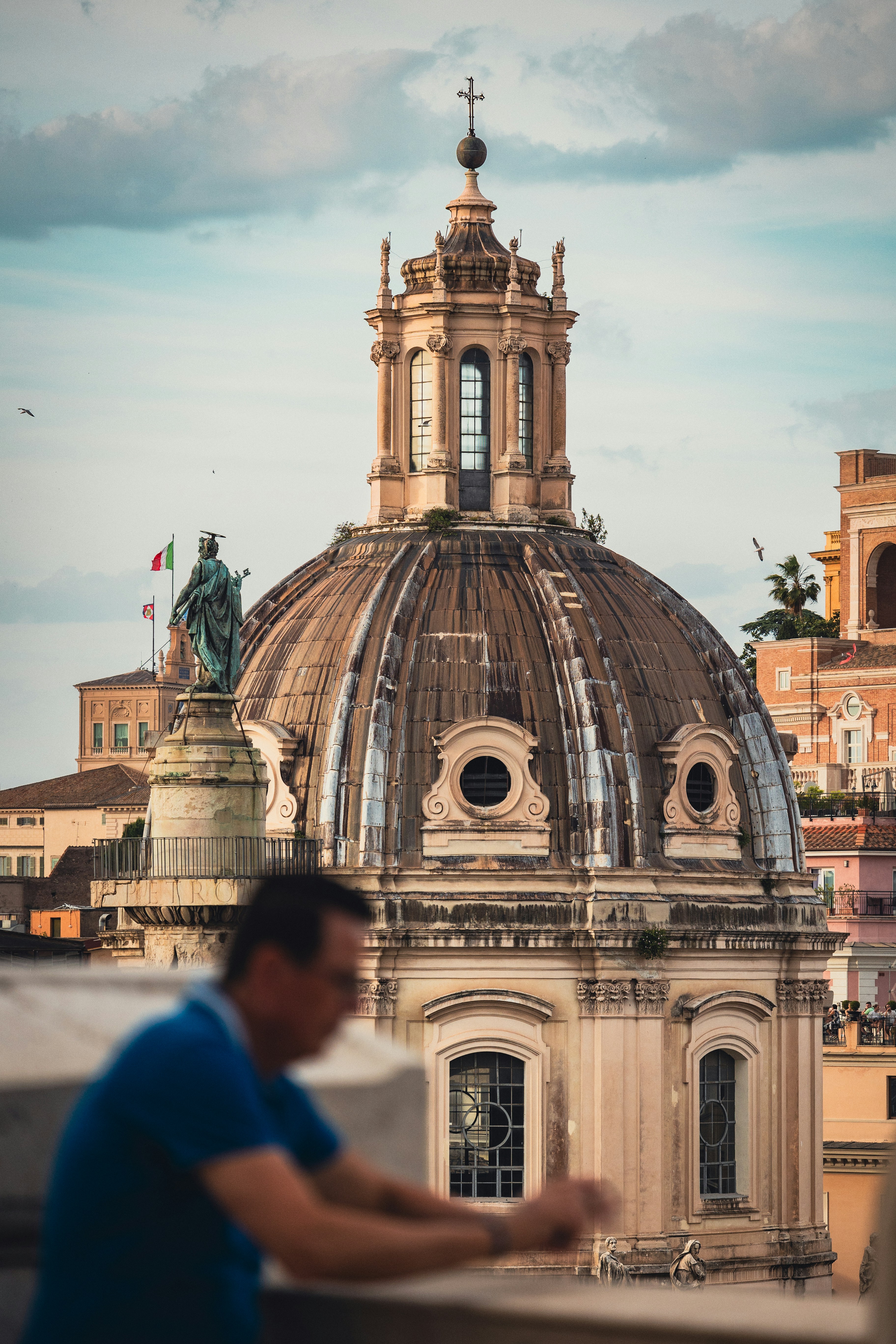 An illustrative photo of a man standing on top of a roof next to a tall building