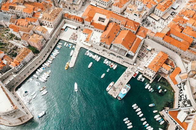 An illustrative photo of a coastal town with terracotta-roofed buildings and a marina