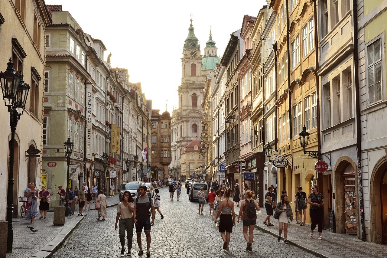 An illustrative photo of a street with people walking along a cobblestone road