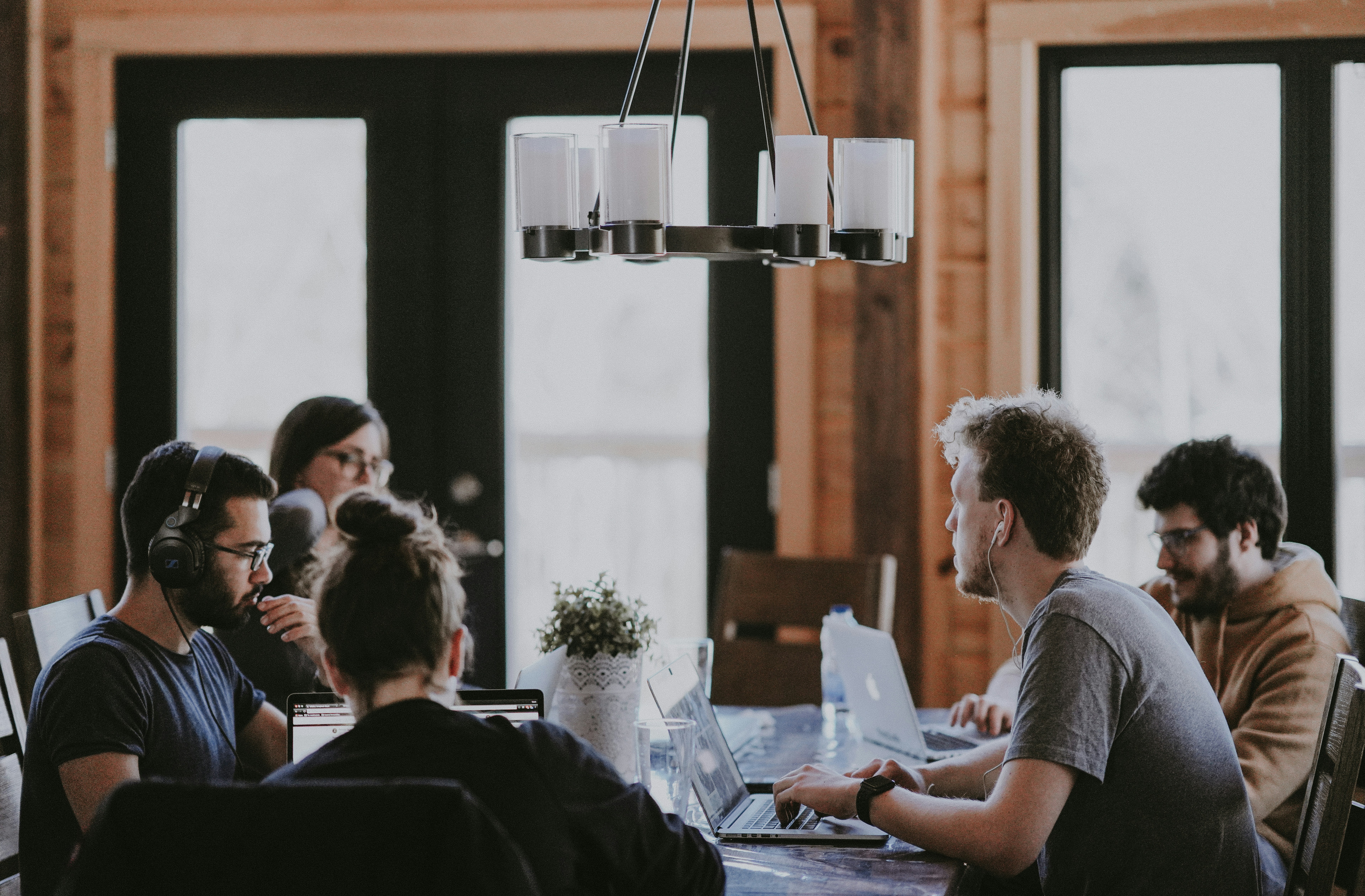 An illustrative photo of people sitting beside a table inside a room