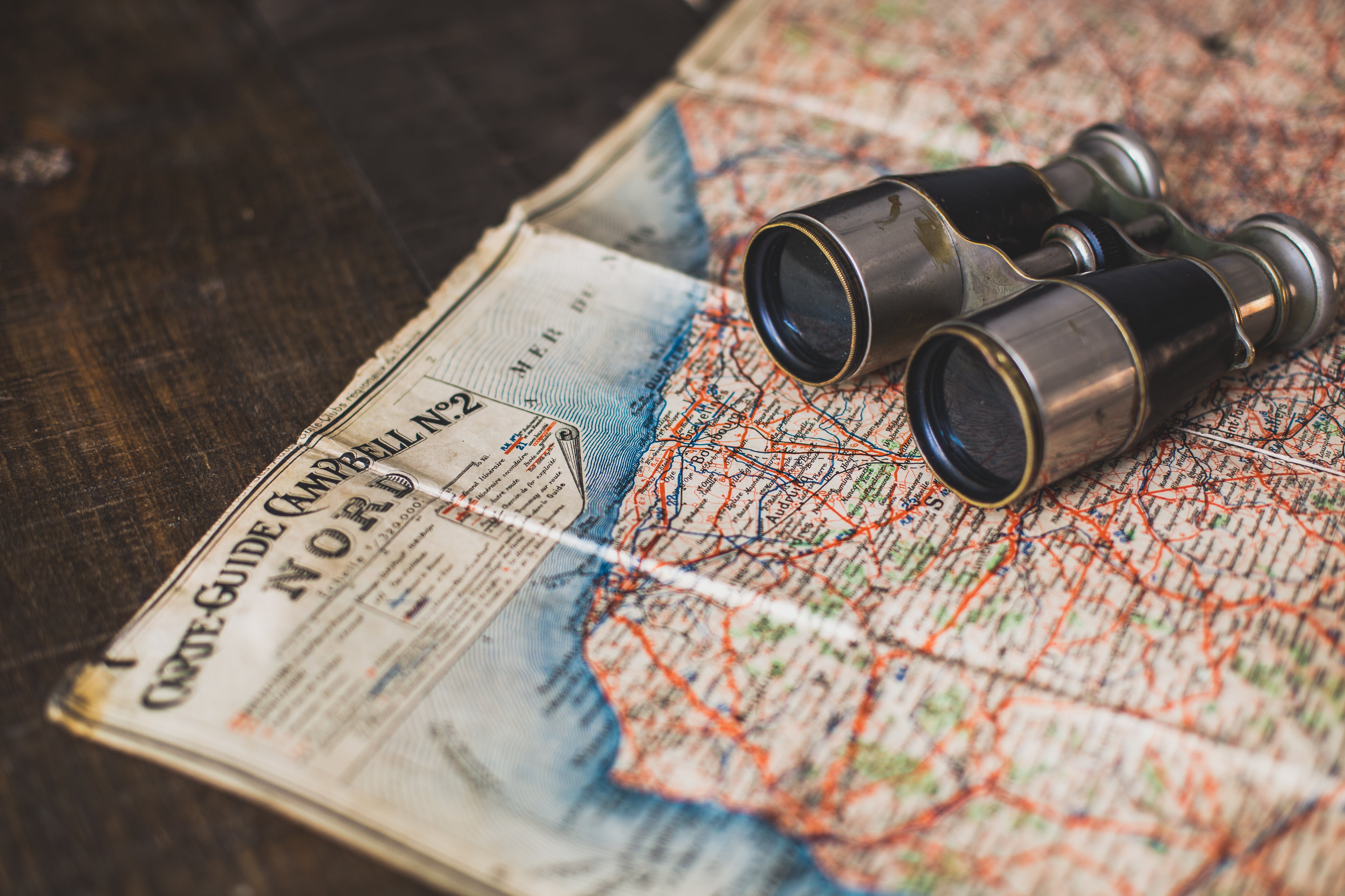 An illustrative photo of antique binoculars on a map