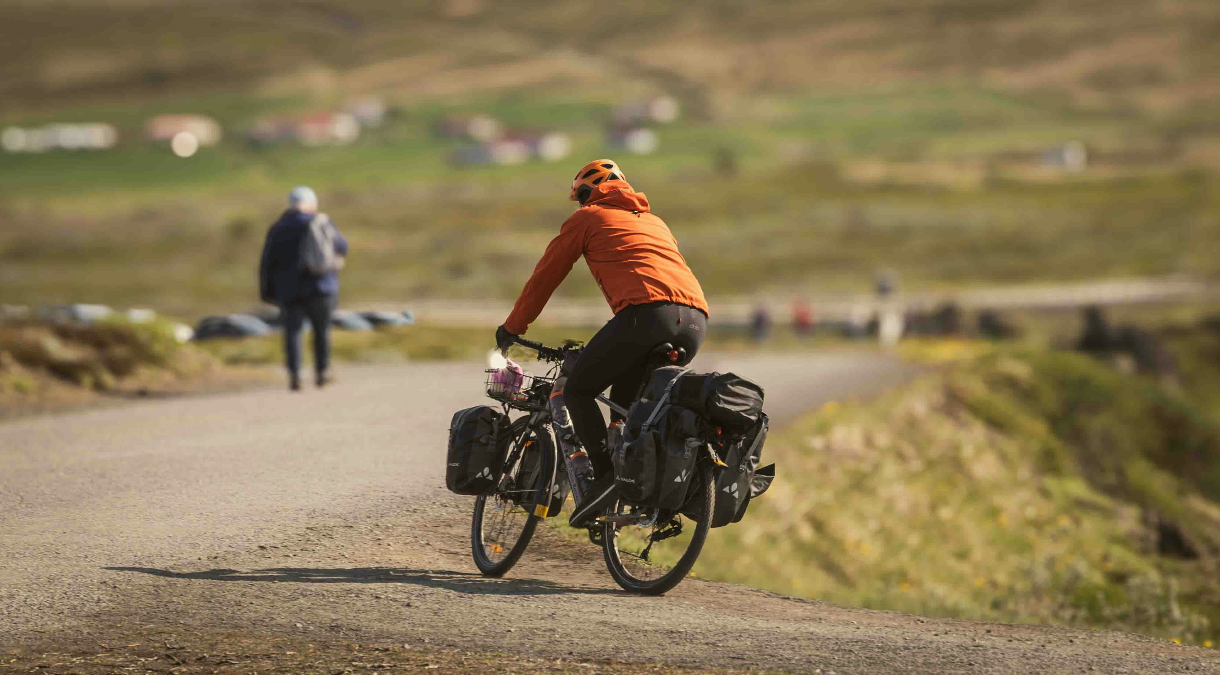 An illustrative photo of a man riding a bike down a road.