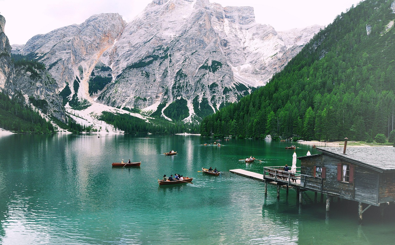 An illustrative photo of boats in a body of water with snowy mountains in the background