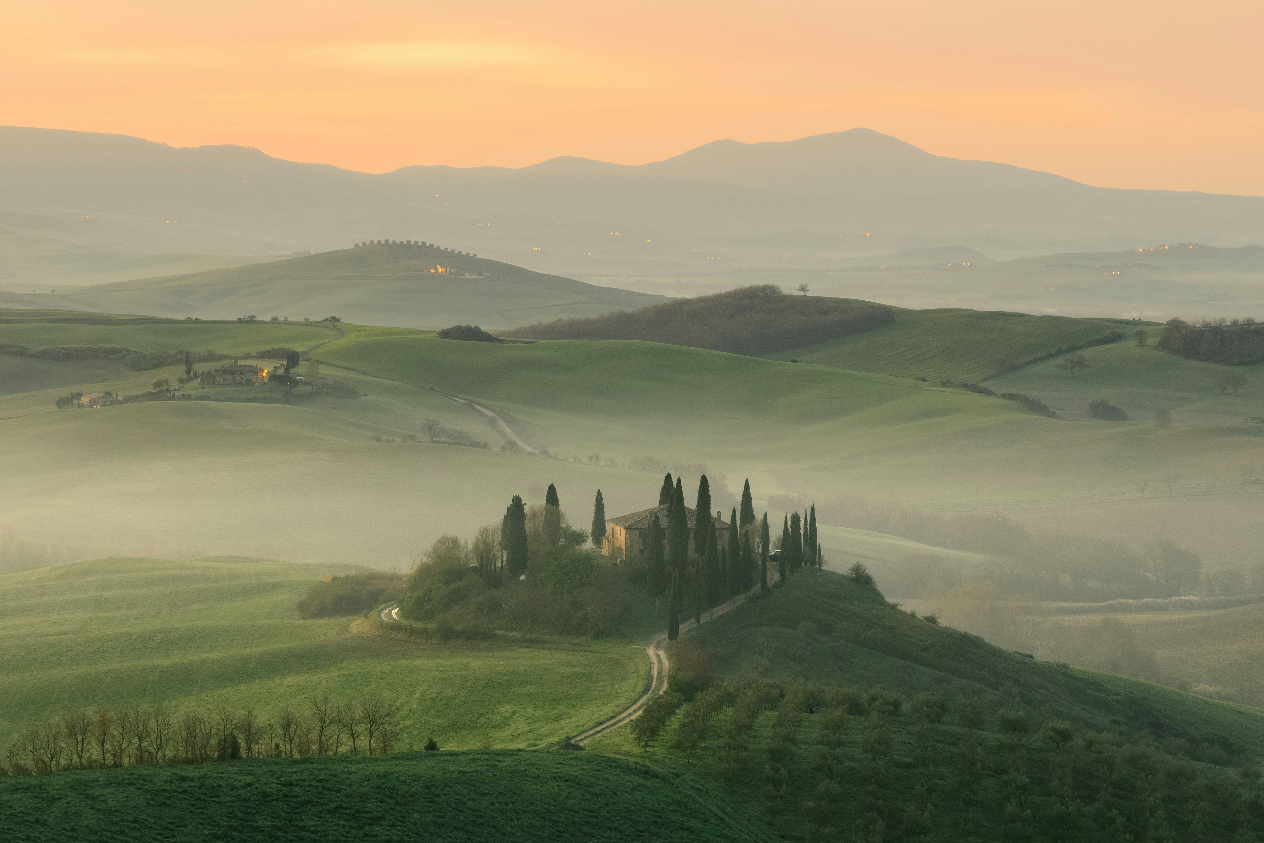 An illustrative photo of a house in the middle of green foggy hills.