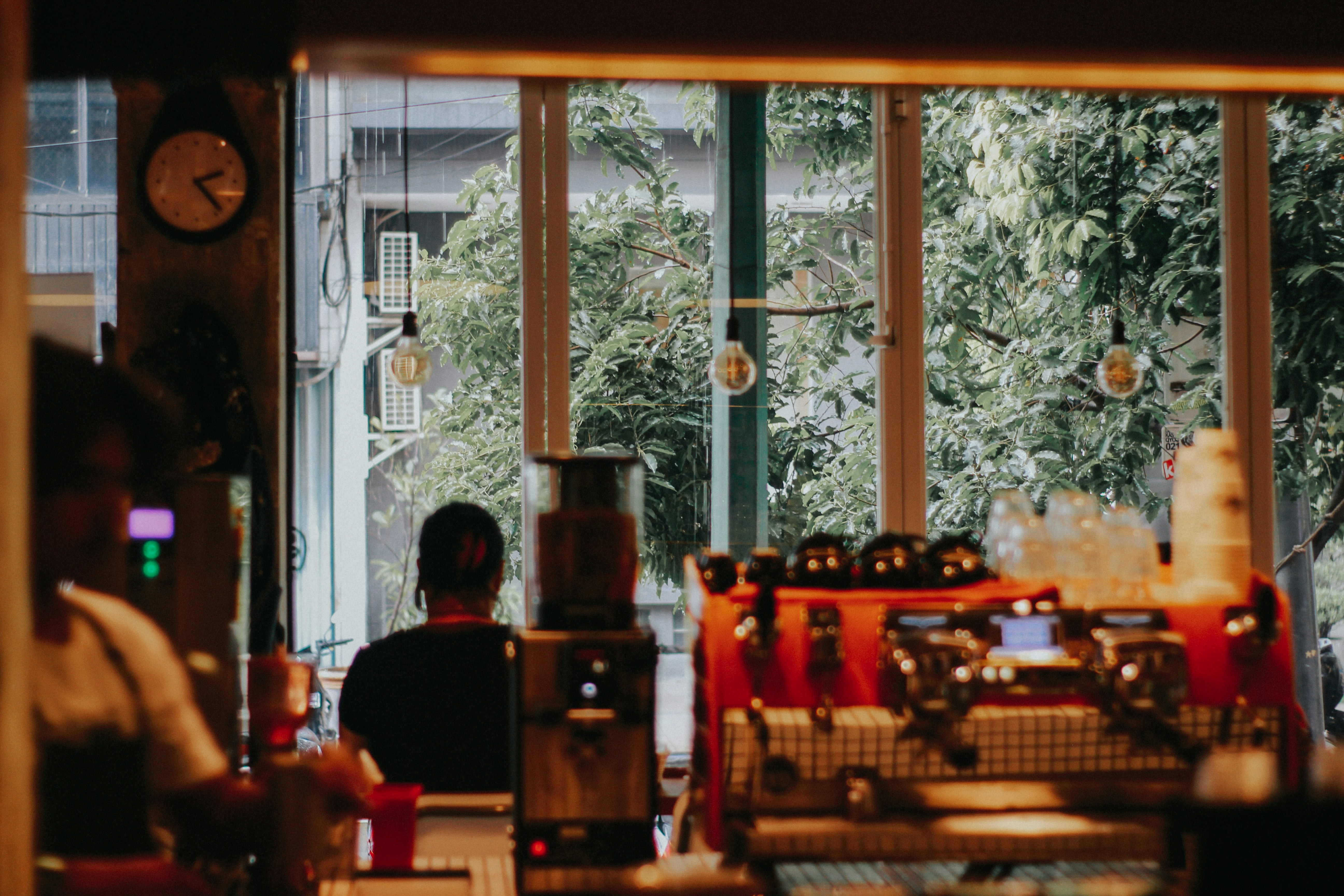 An illustrative photo of a man sitting at a table in front of a window.