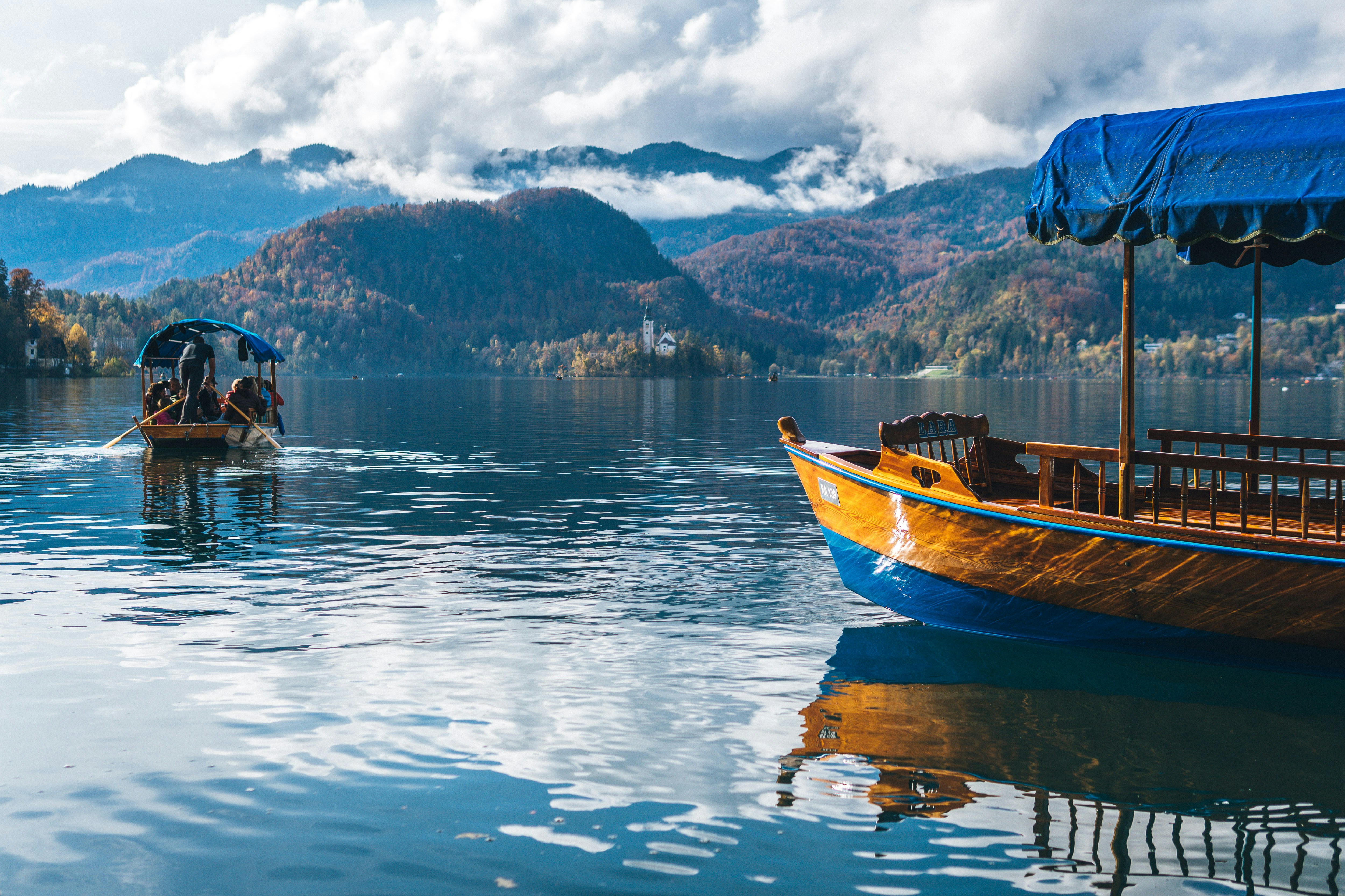 An illustrative photo of a boat on water near mountain.