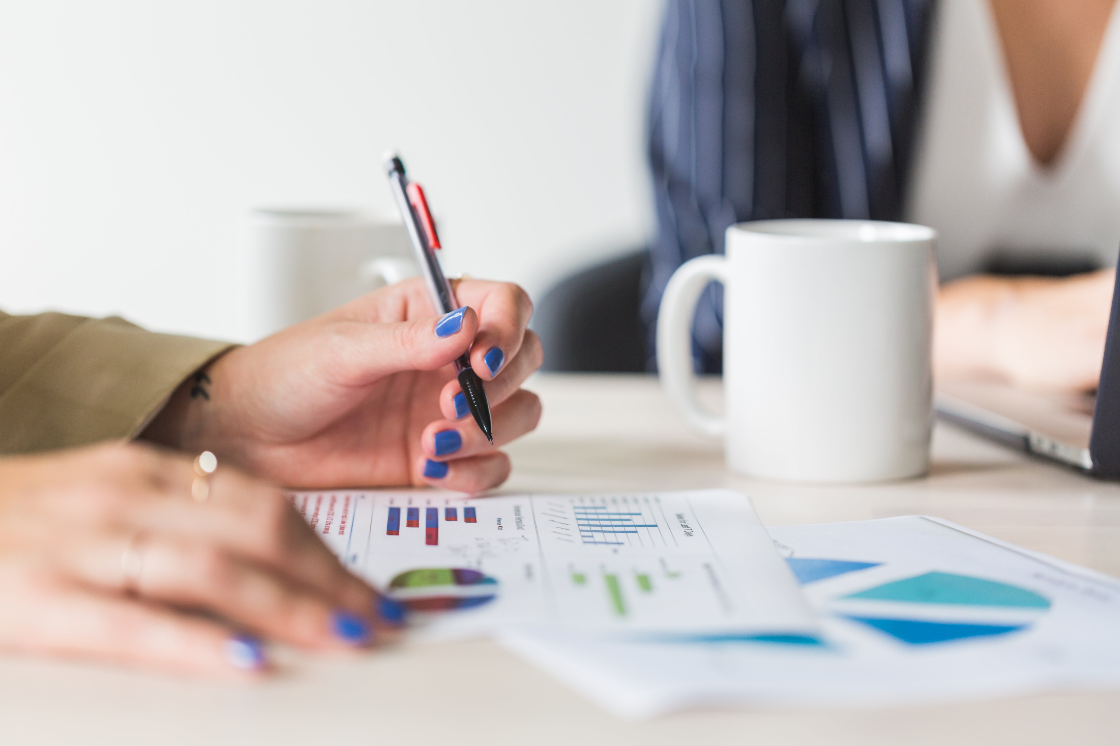 An illustrative photo of a woman holding a pencil at meeting