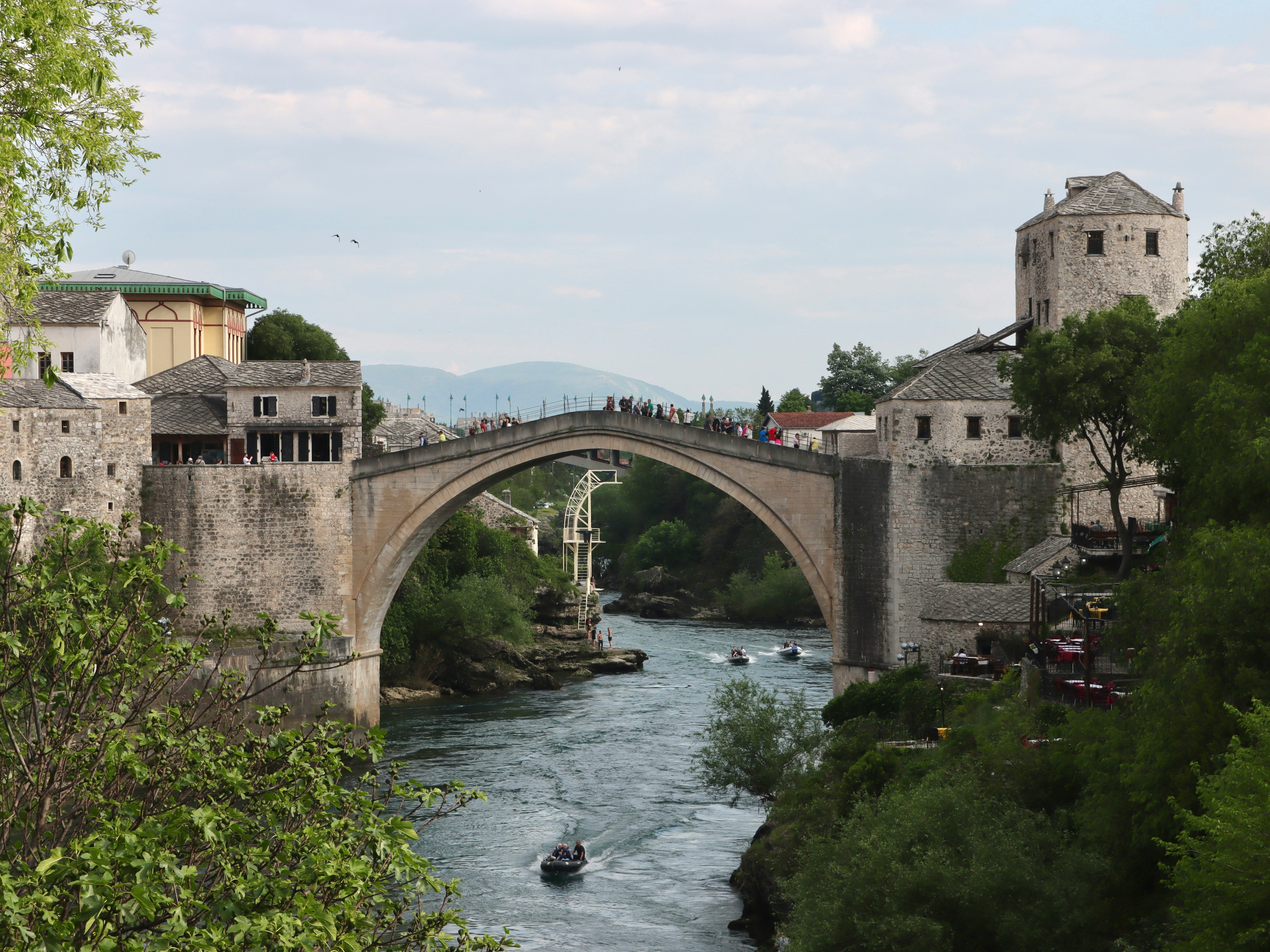 An illustrative photo of a bridge over a river with a boat on it.