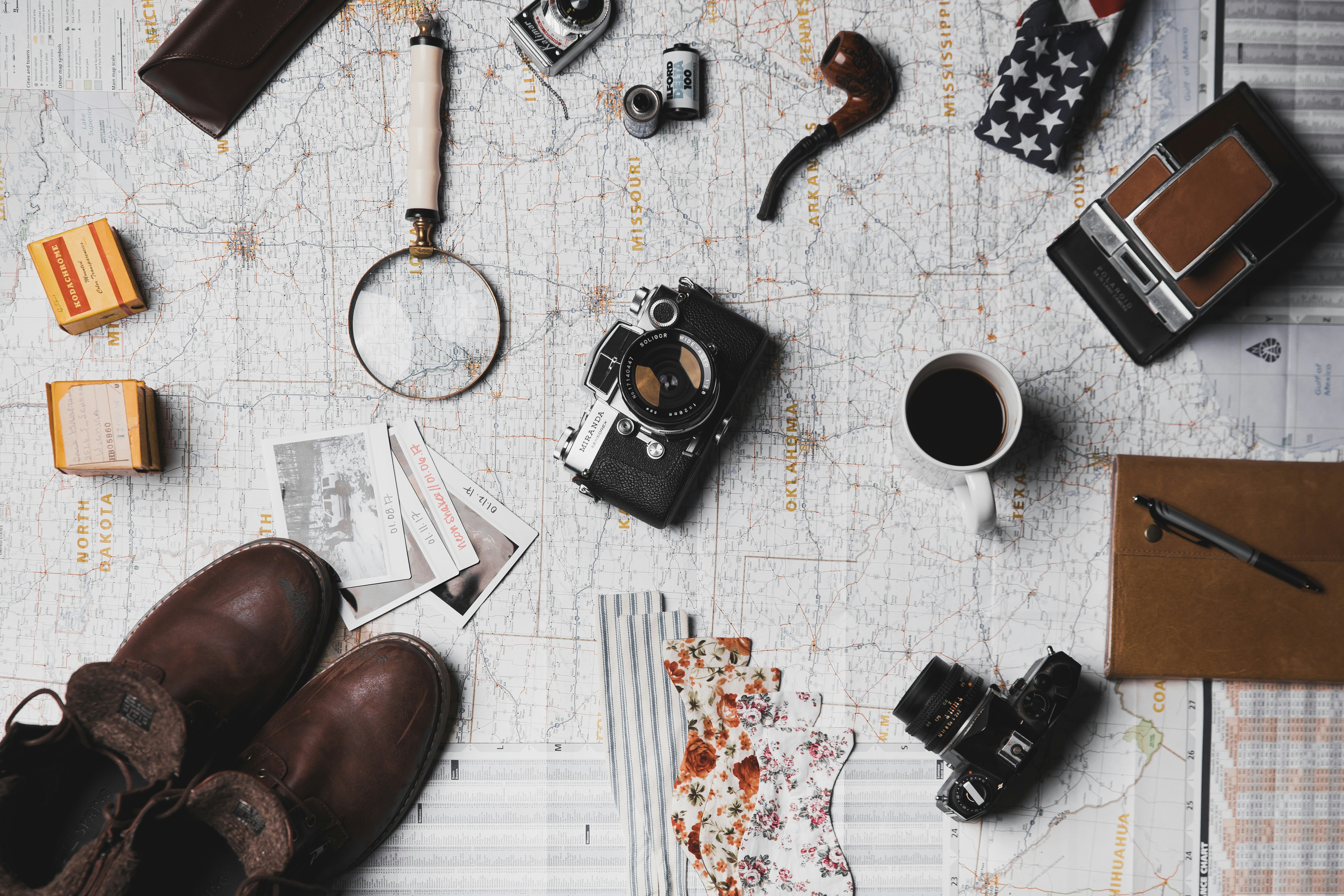 An illustrative photo of a collection of travel-related items laid out on a map.