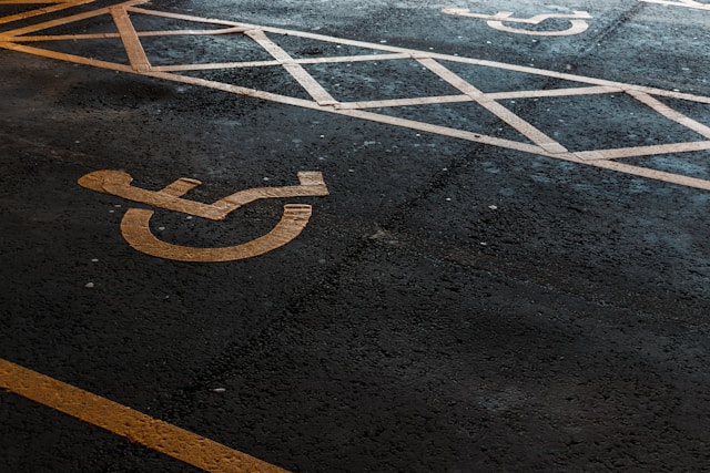 An illustrative photo of a parking space with a clearly marked handicapped sign painted on the asphalt