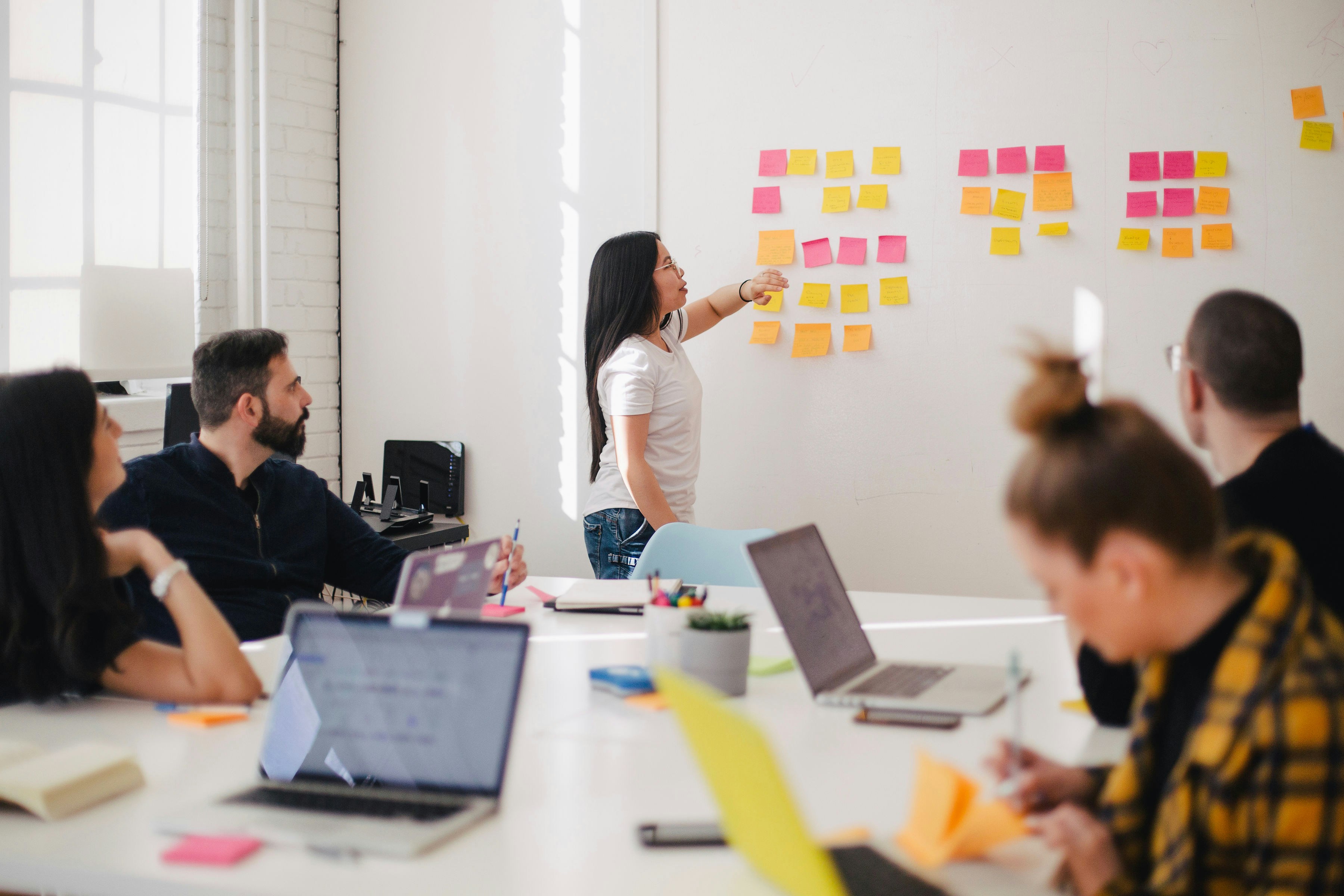 Photo by Unsplash An illustrative photo of a group of people in a bright room, engaged in a collaborative work session.