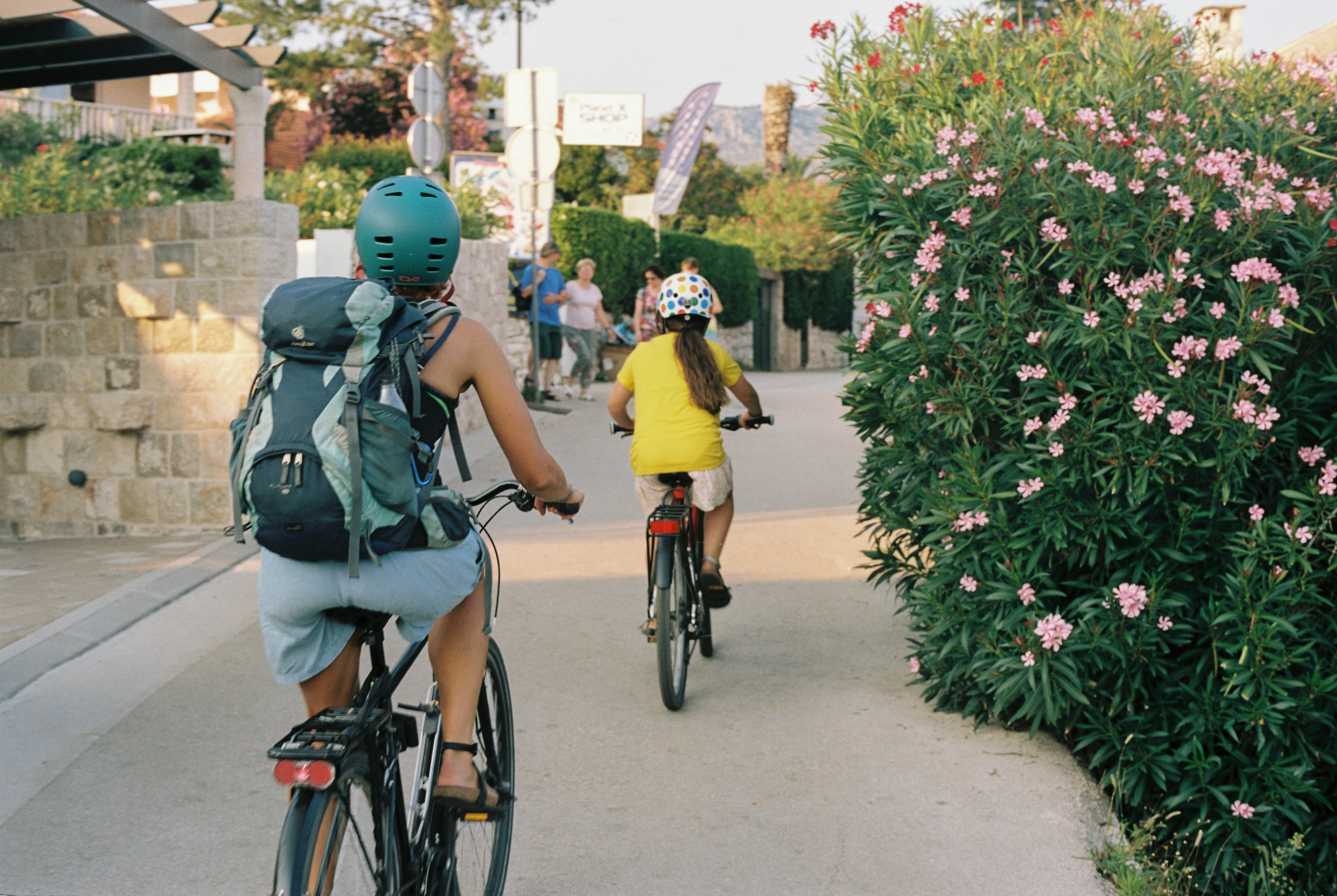 An illustrative photo of a couple of people riding bikes down a street