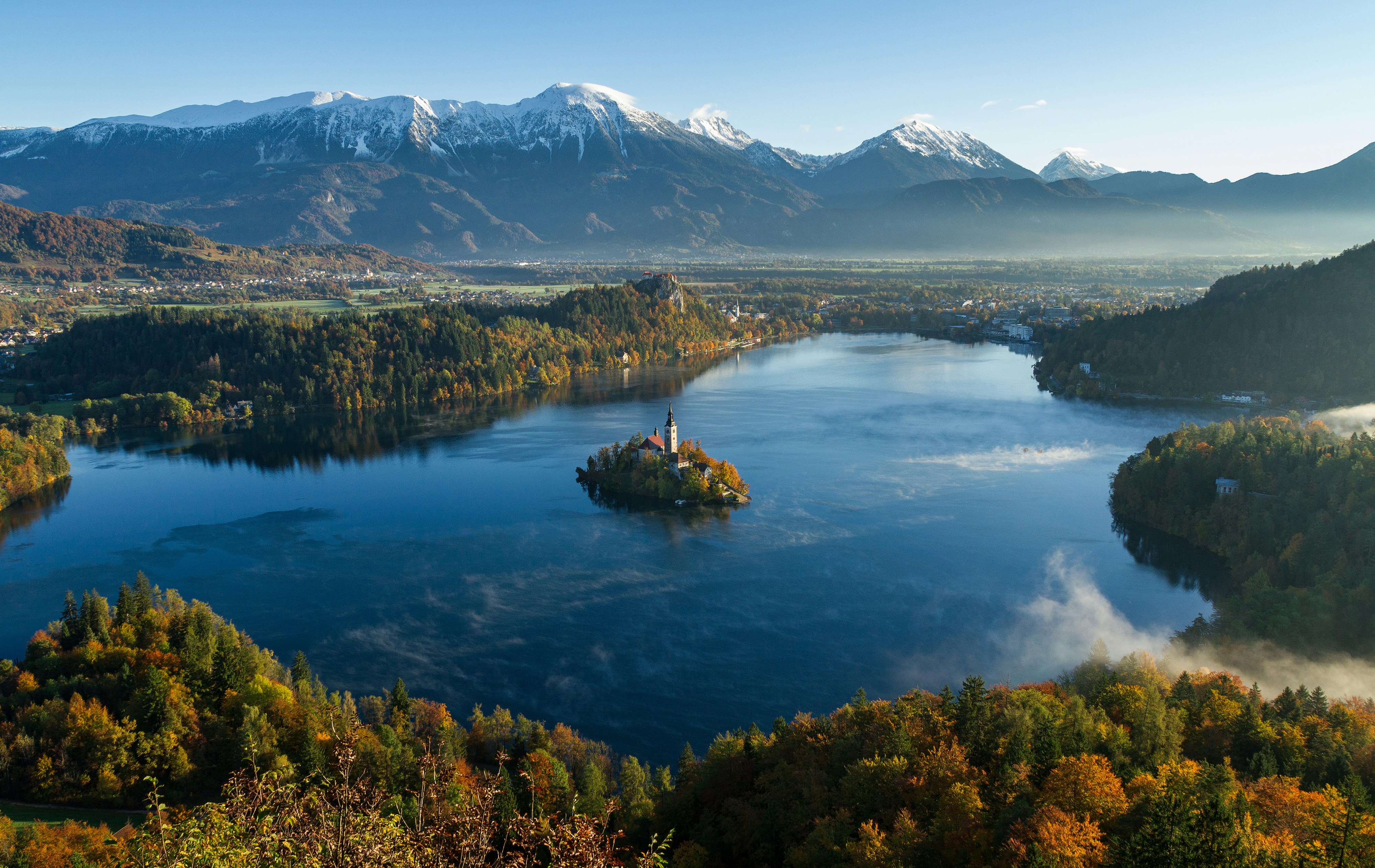 An illustrative photo of an island surrounded by water and mountains.