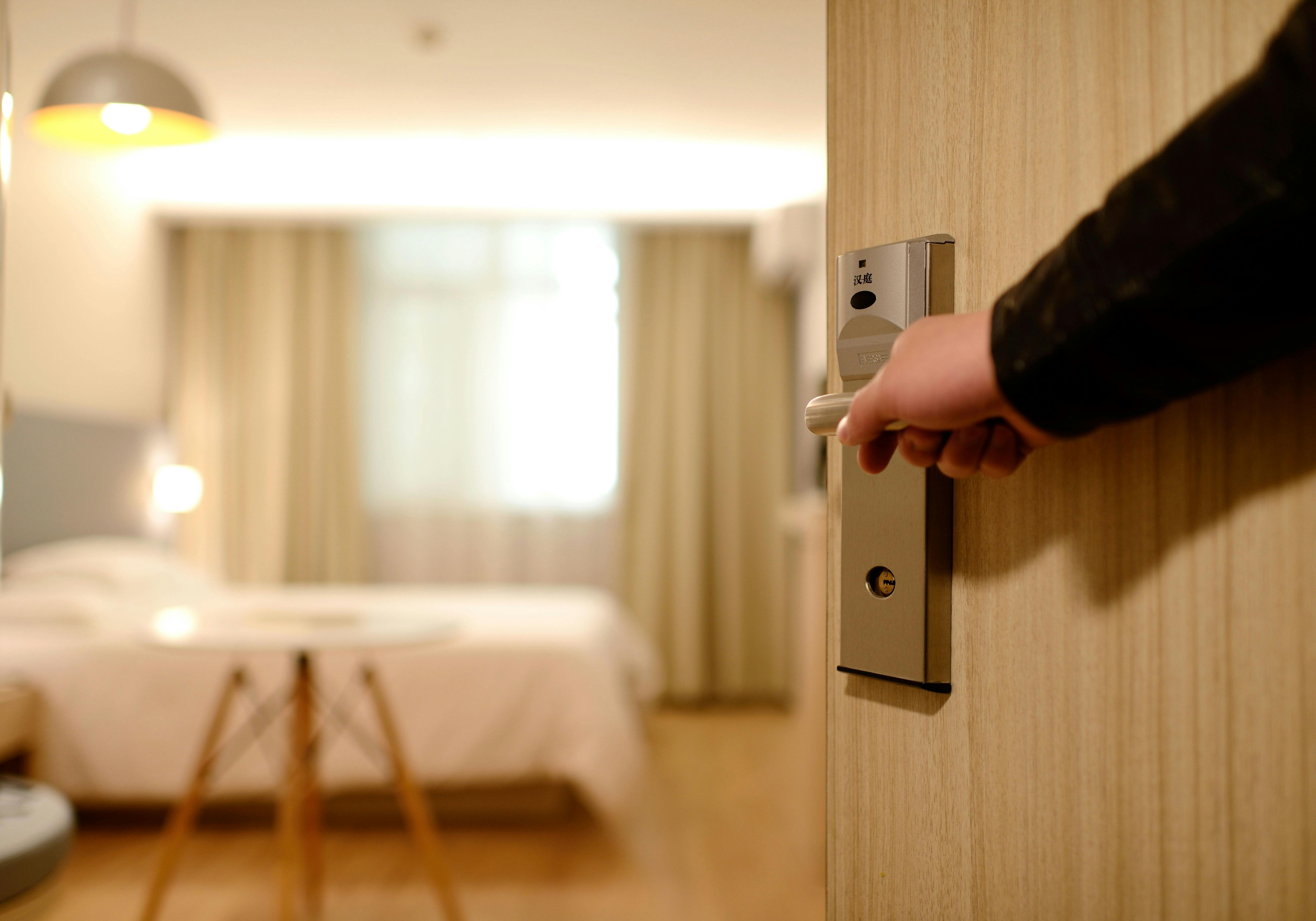 Photo by Pexels An illustrative photo of a person holding on door lever inside room.