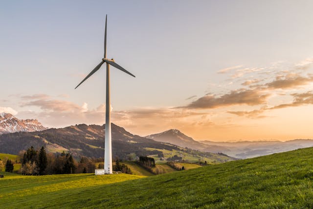 An illustrative photo of a white windmill standing tall against a clear sky