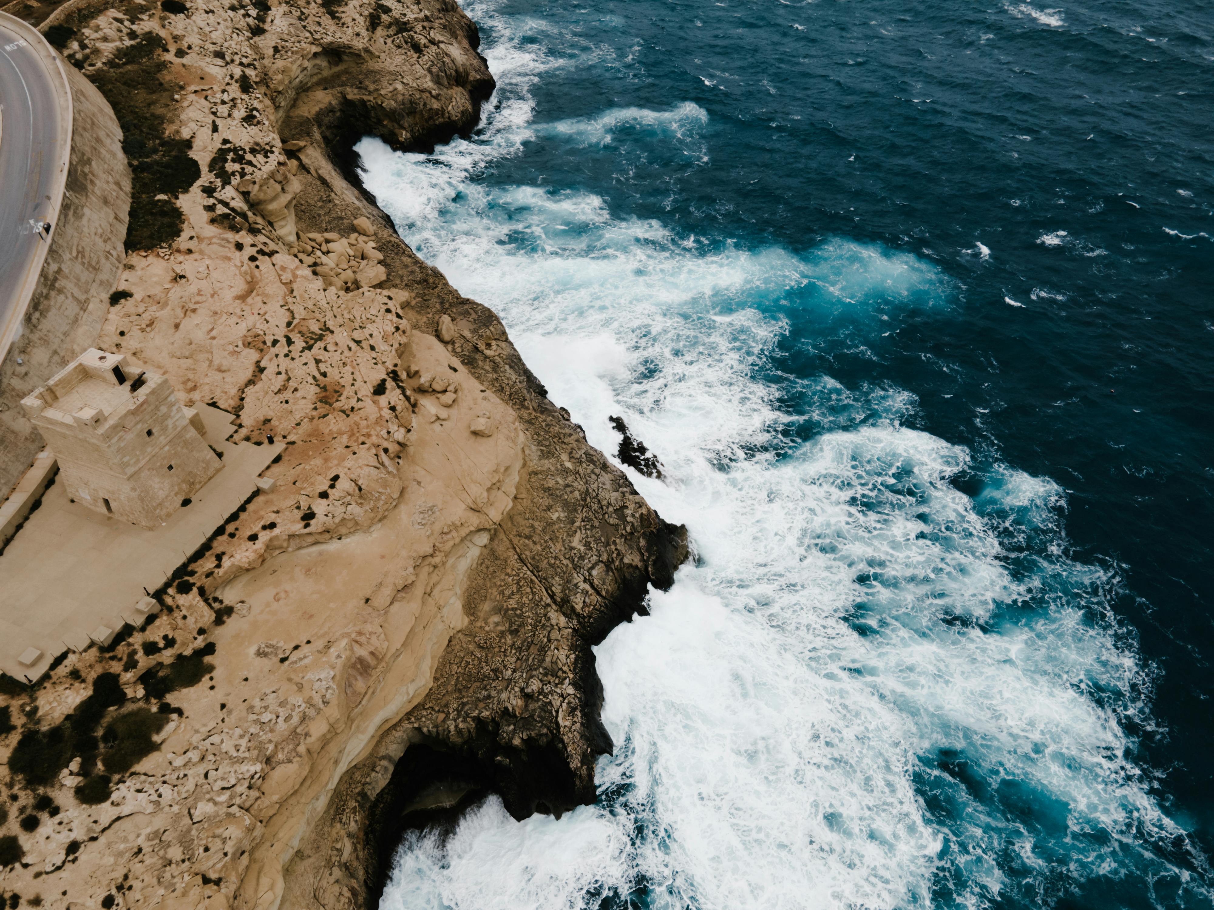 An illustrative photo of a brown rocky mountain beside blue sea