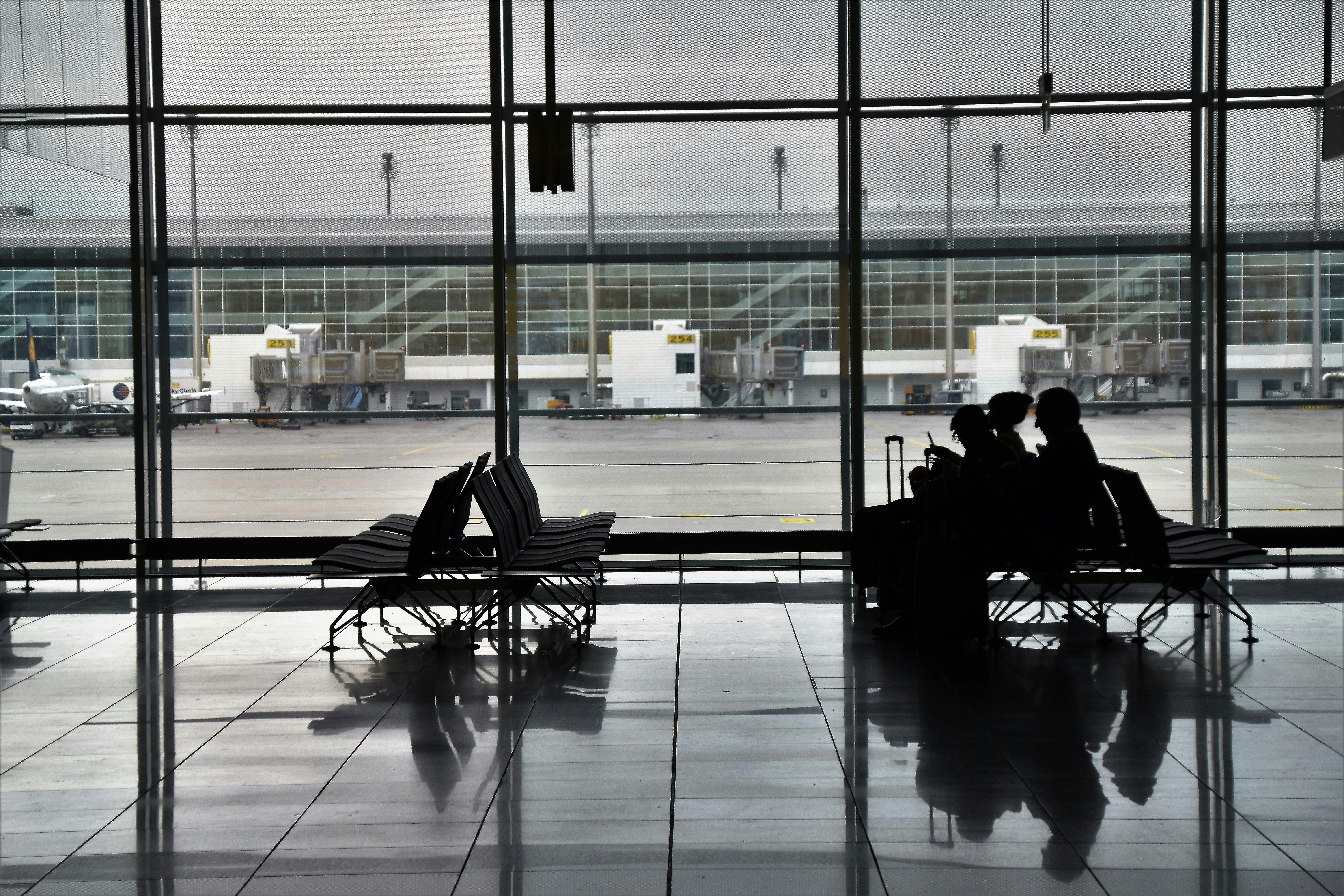 An illustrative photo of people sitting on chairs in airport.