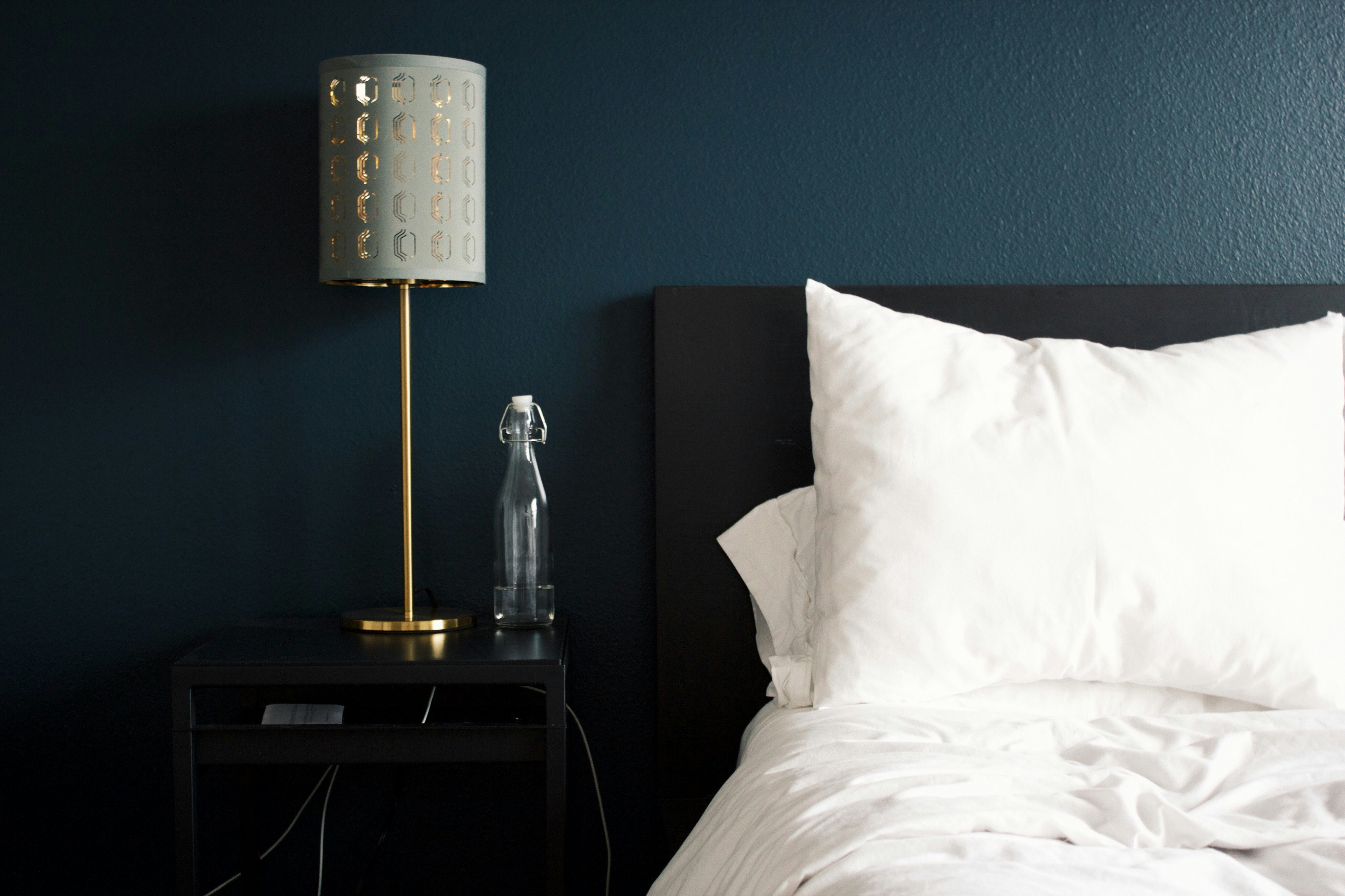 An illustrative photo of a bedroom with a focus on a bedside area.