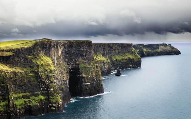 An illustrative photo of a sea and a cliff during daytime