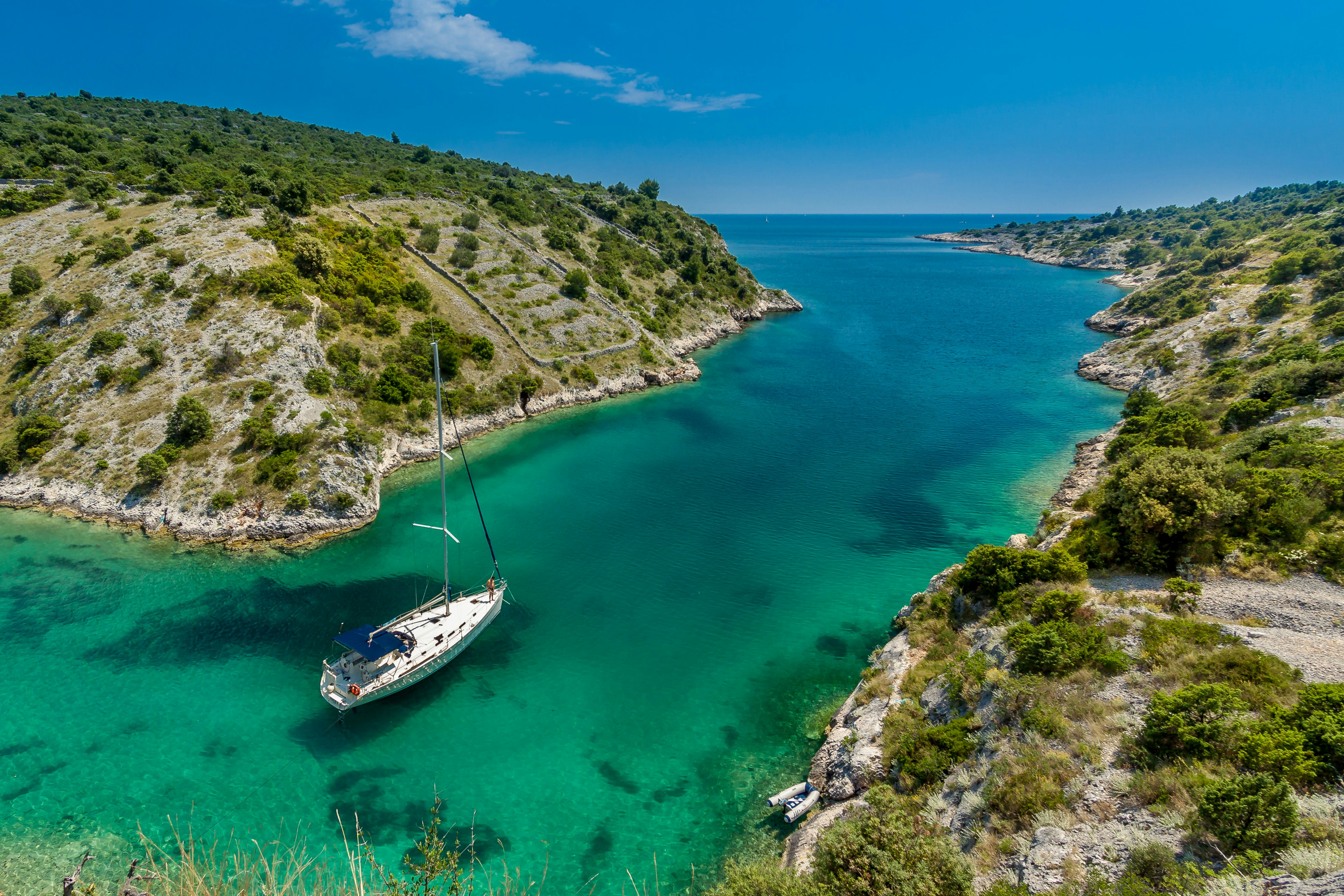 An illustrative photo of a white and blue boat floating on the sea.