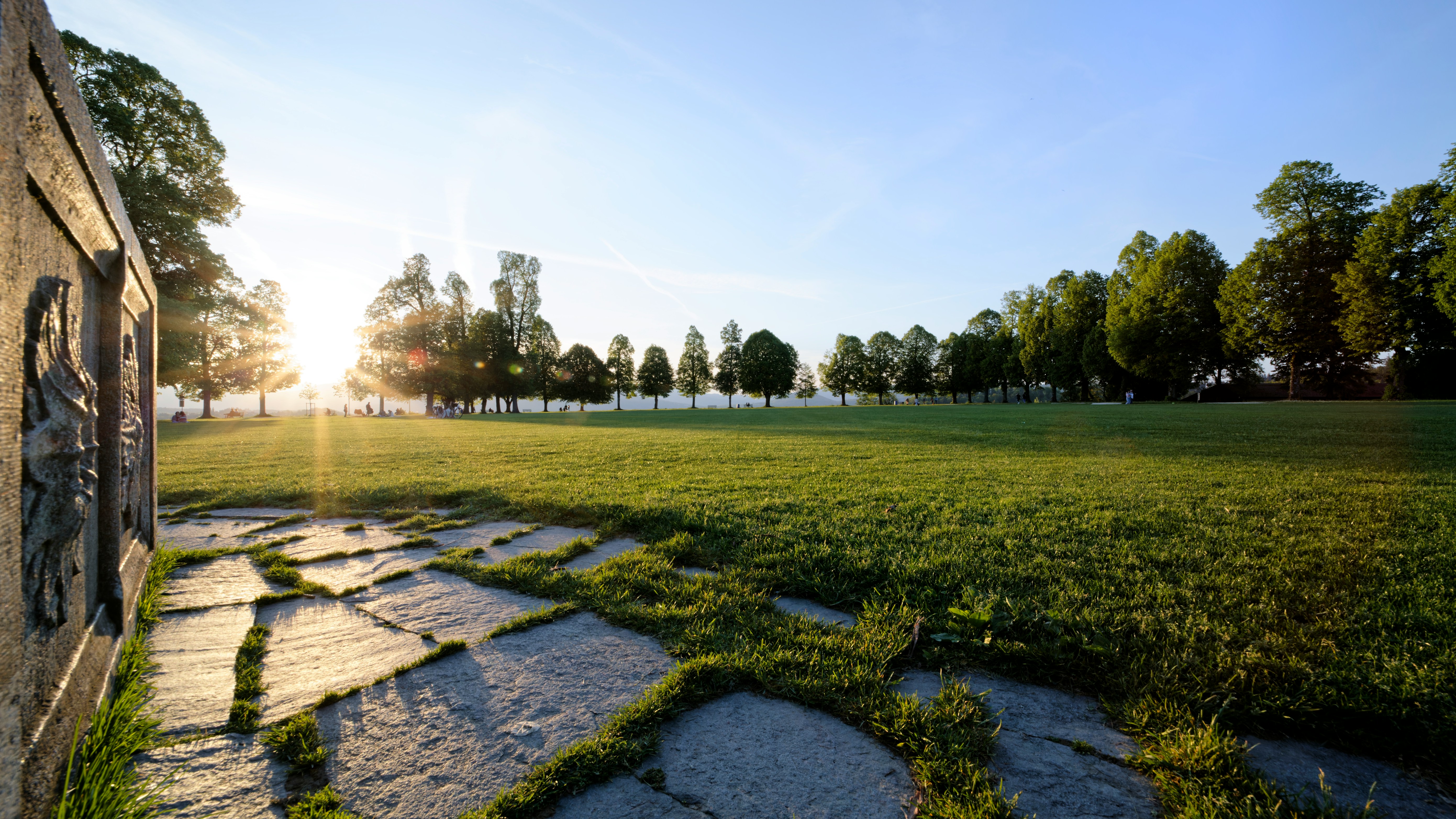 An illustrative picture of a sunset over a meadow near a house