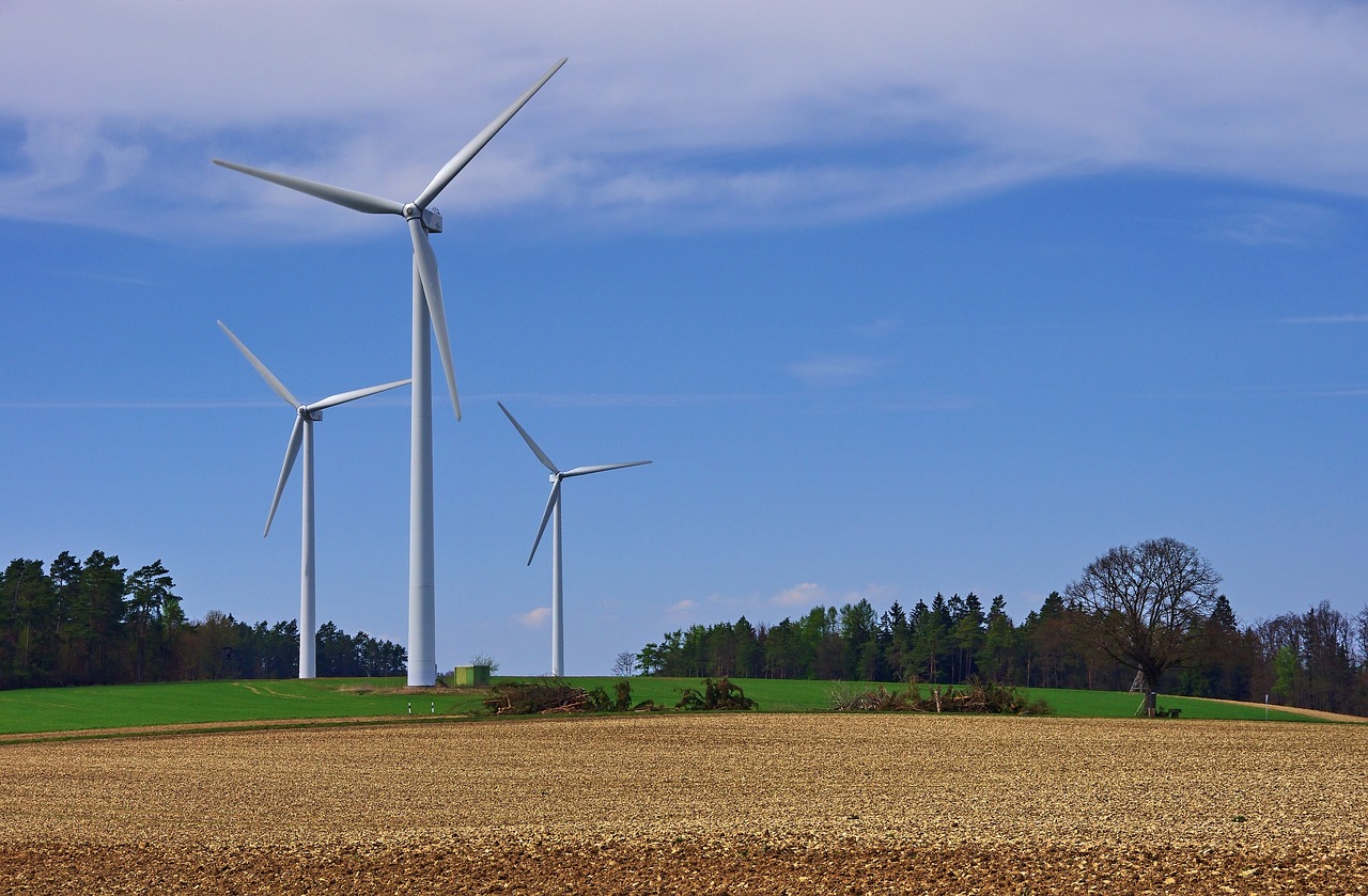 Photo by Pixabay An illustrative photo of wind turbines standing tall in a plowed field under a clear blue sky