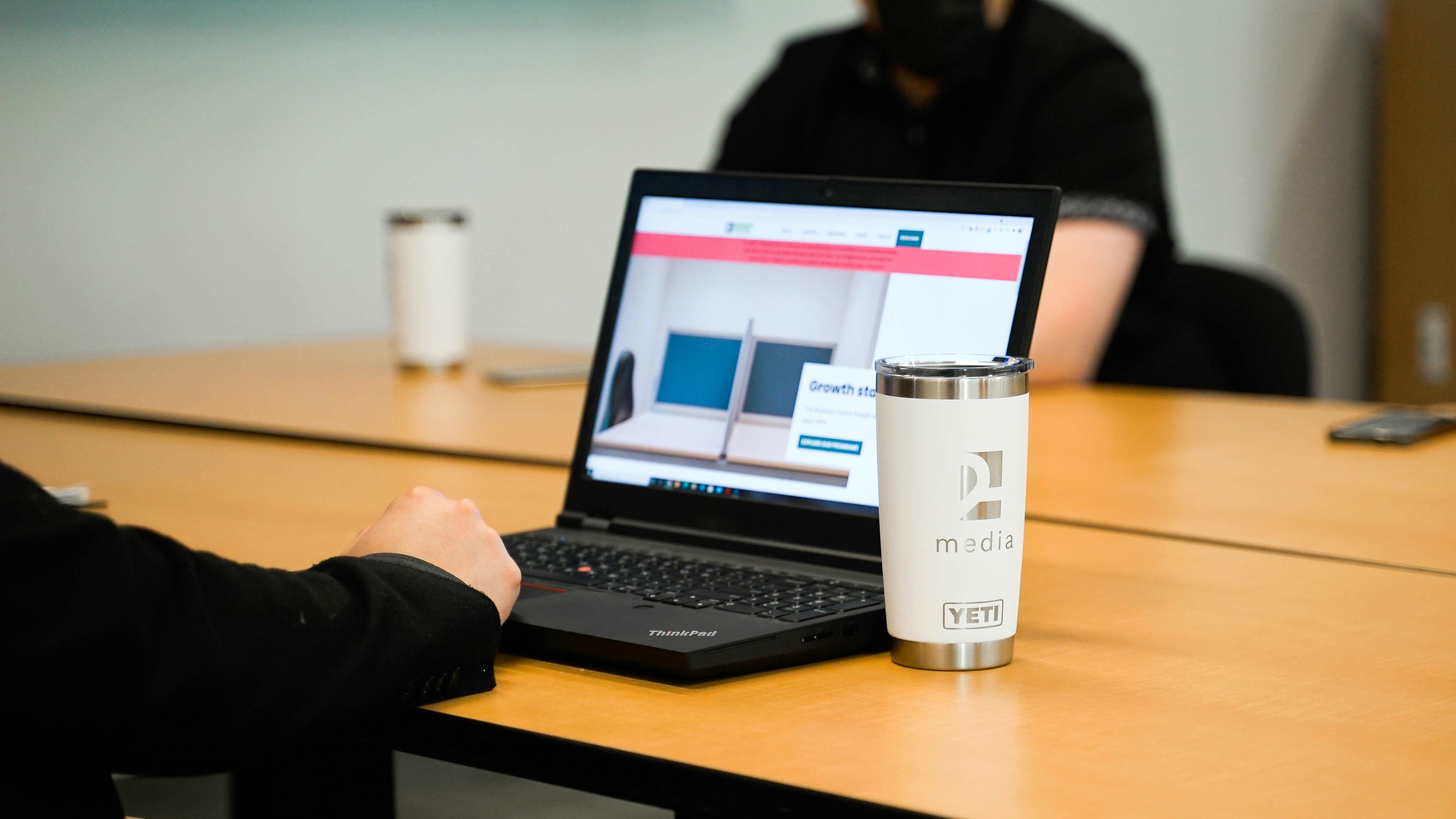 An illustrative photo of a person working on a laptop on a table