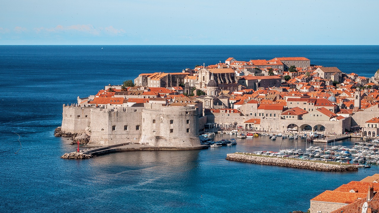 An illustrative photo of buildings with orange roofs on the coast near the sea