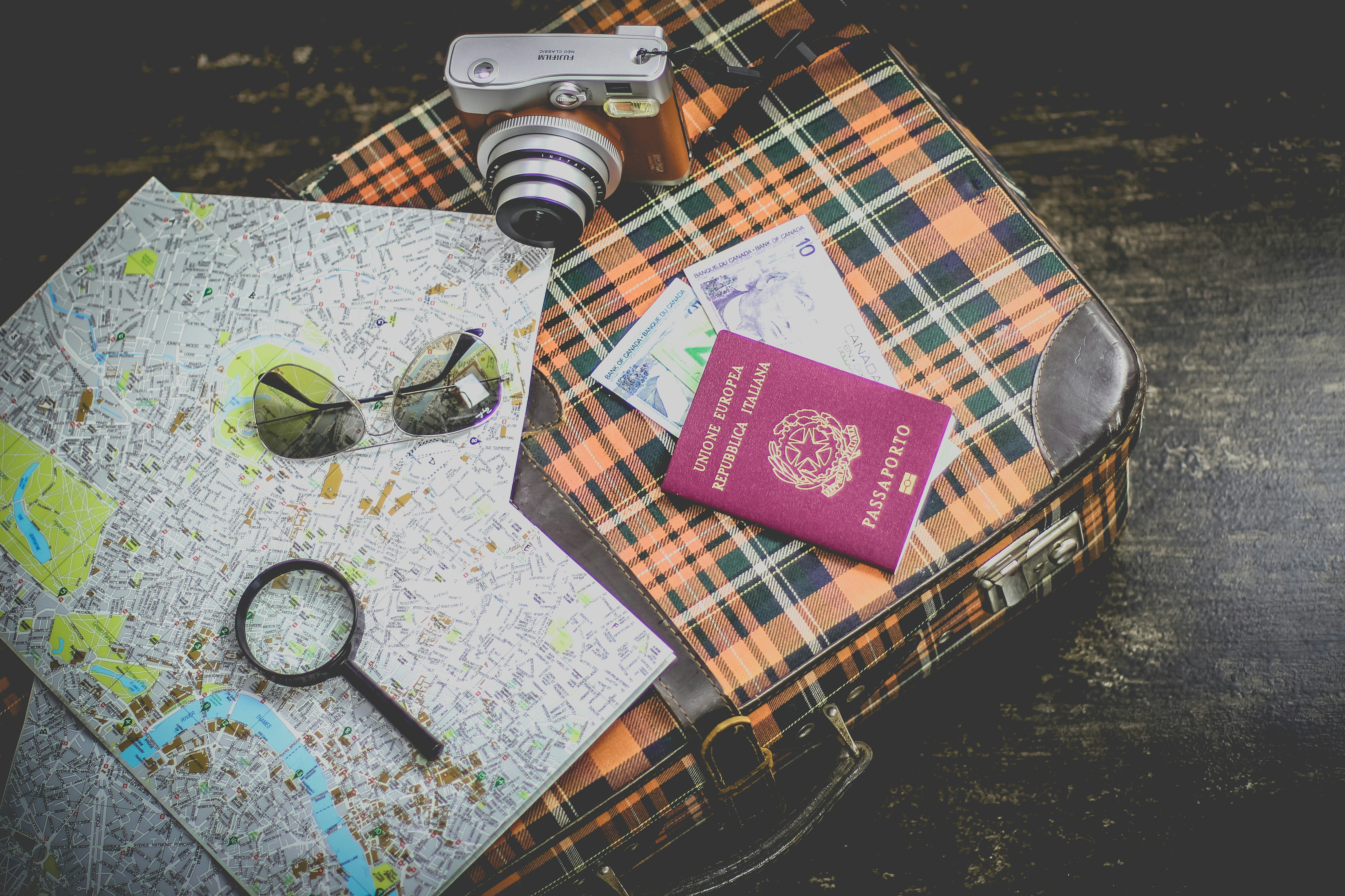 An illustrative photo of a passport on a suitcase near the map 