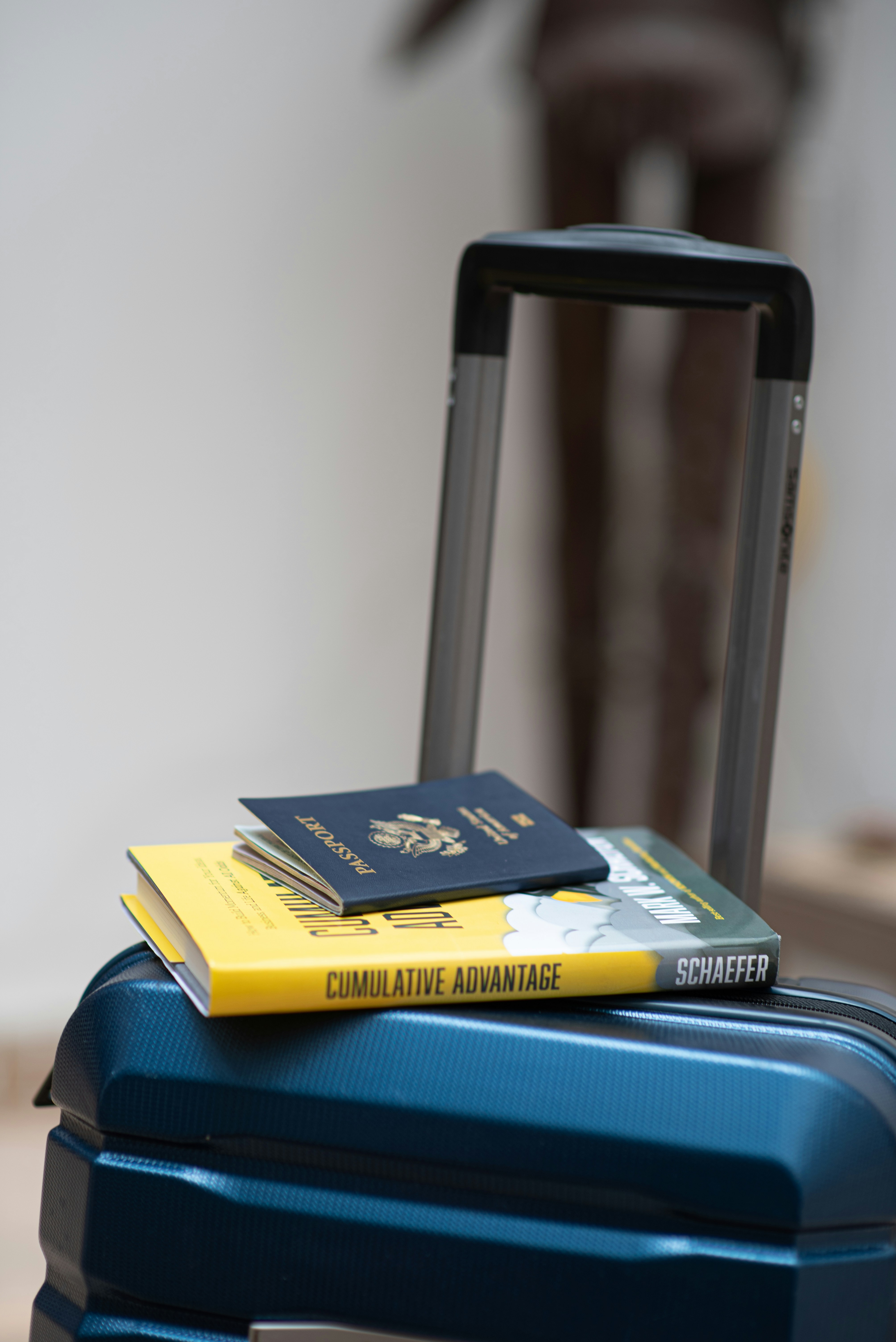 An illustrative photo of a suitcase with a book and a passport on top