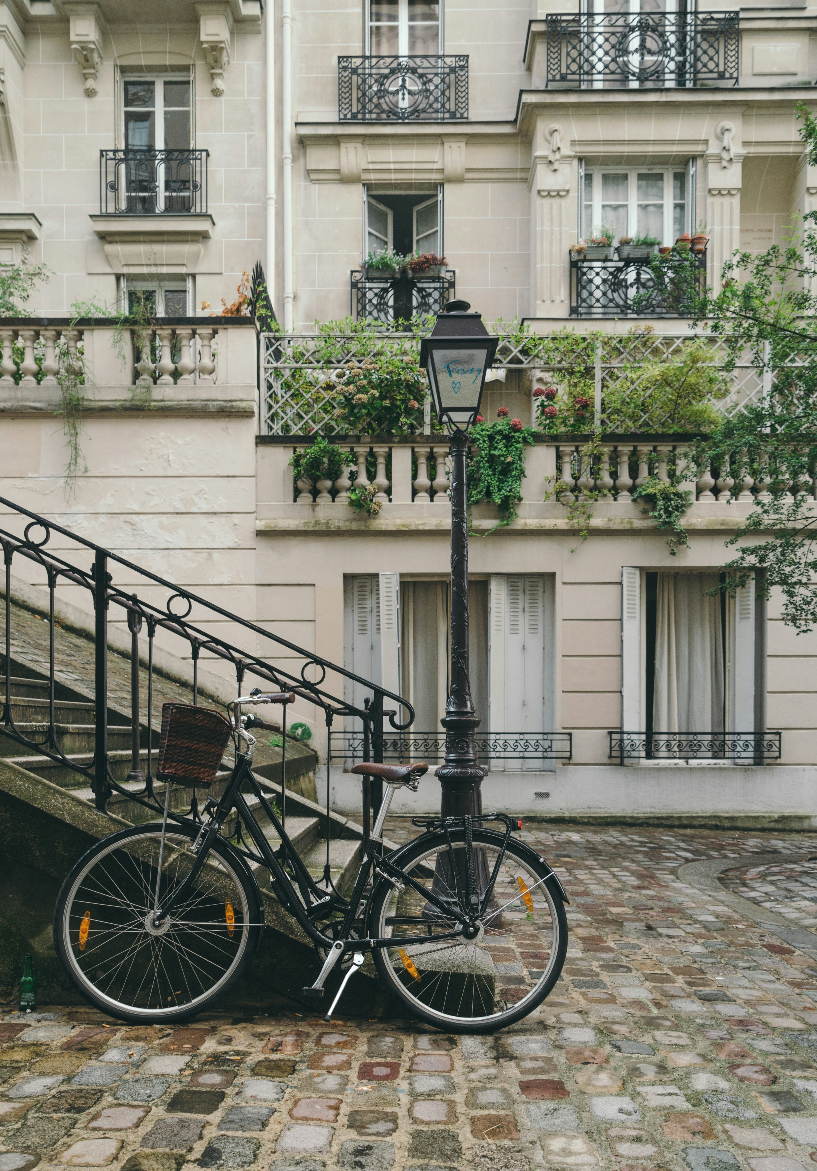 An illustrative photo of a bike leaning against handrail in front of French buildings