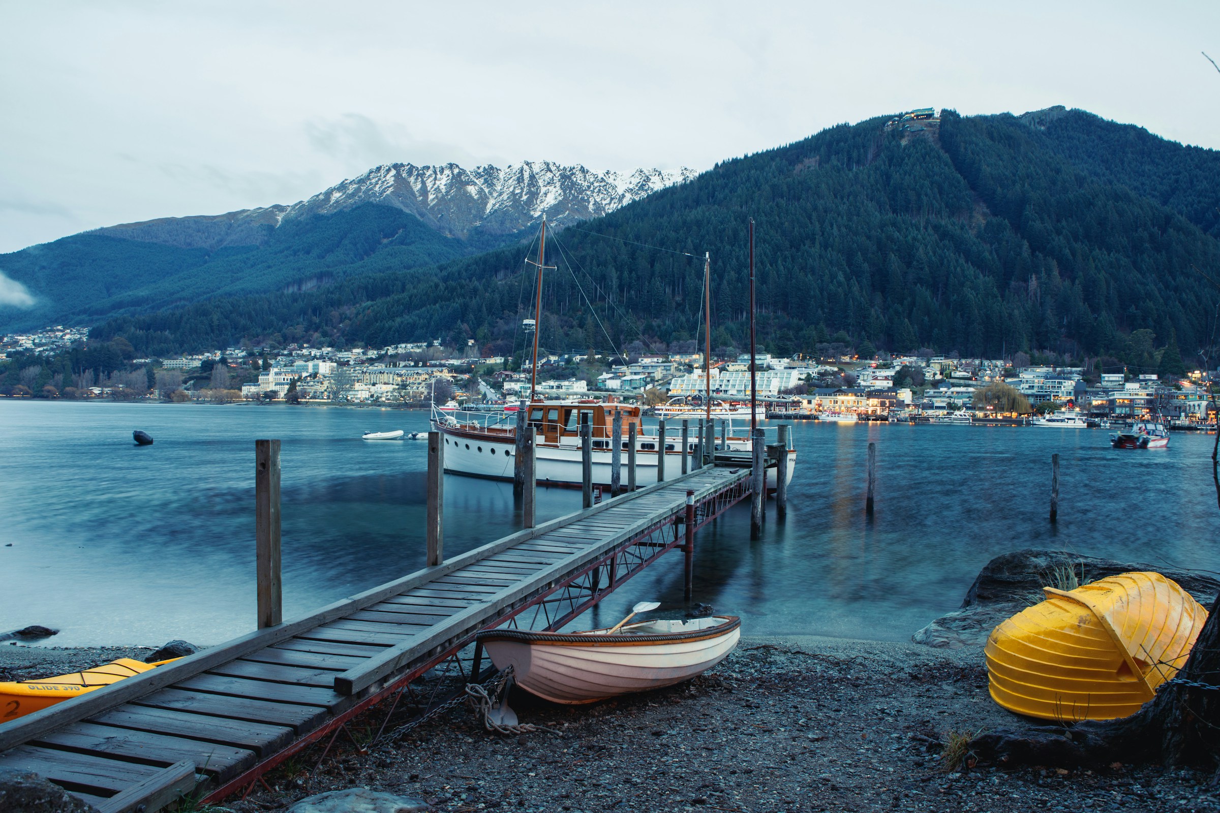 An illustrative photo of several boatі besides wooden dock.