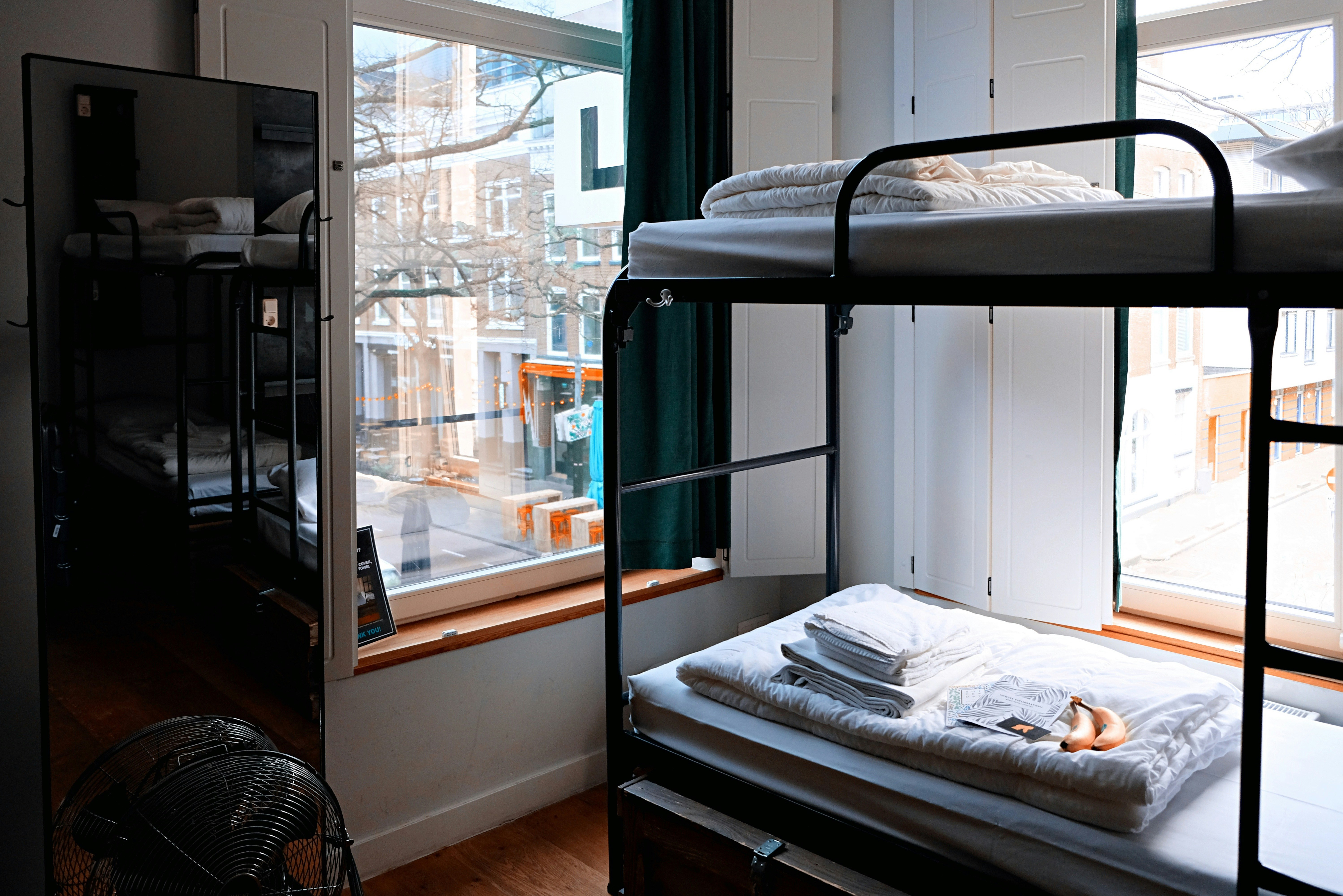 An illustrative photo of a hostel with black metal bunk bed