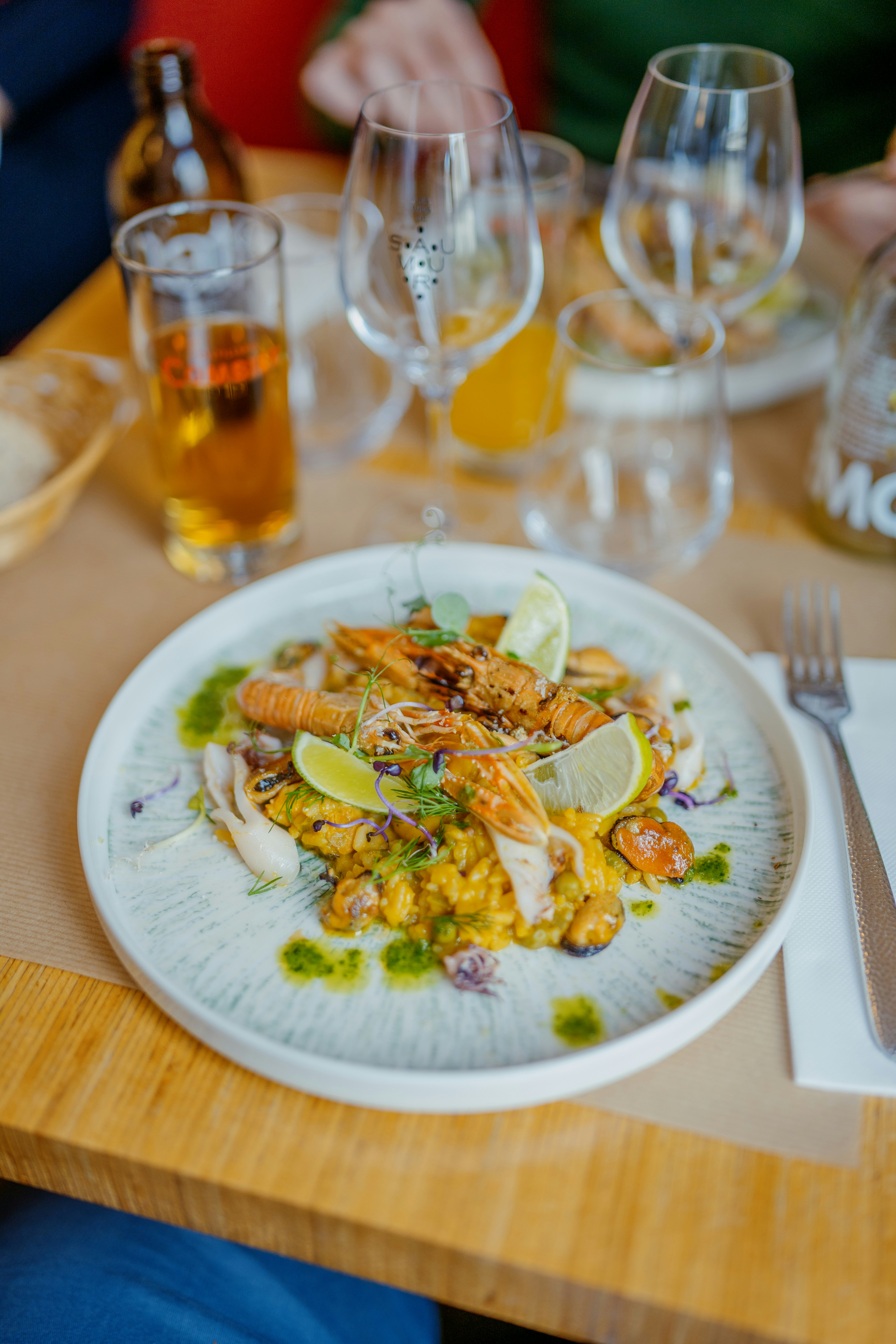 An illustrative photo of a plate of food on a table with wine glasses