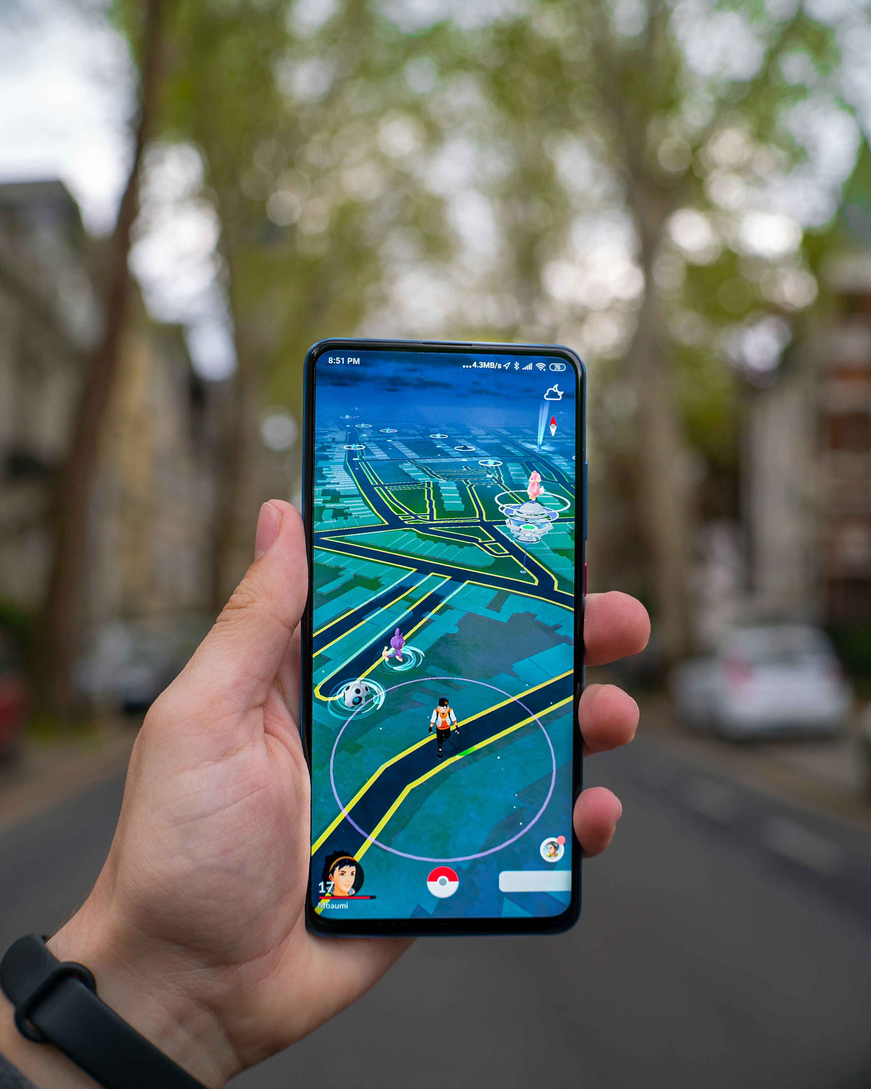 An illustrative photo of a person holding black smartphone with a game in it