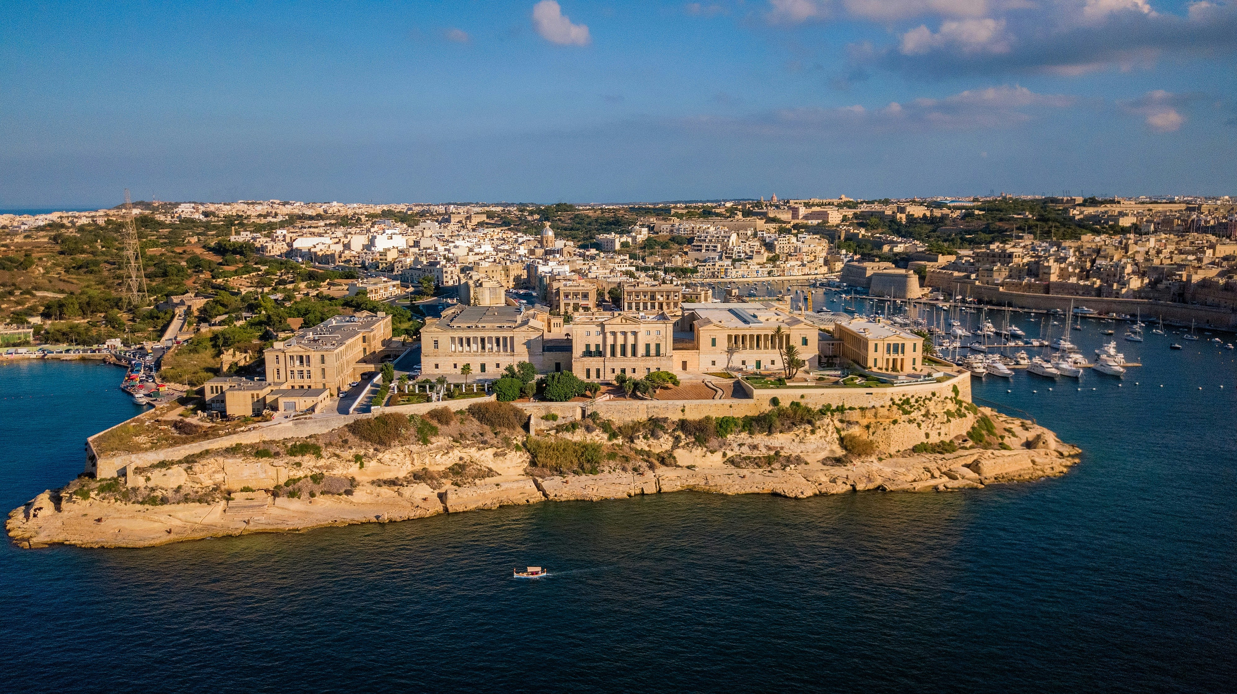 An illustrative photo of an island with buildings on it near a body of water 