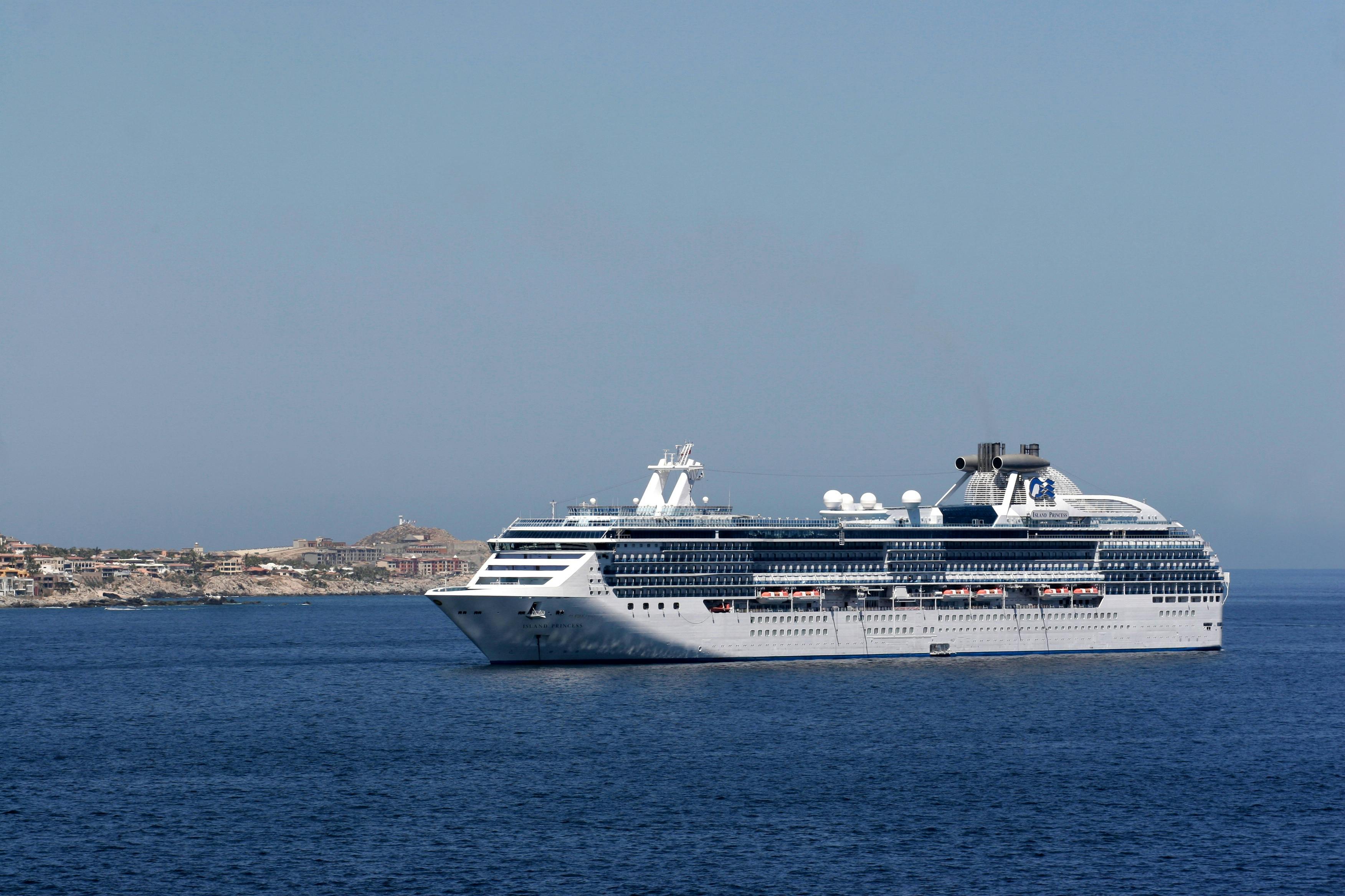 An illustrative photo of a white cruise ship sailing on the sea