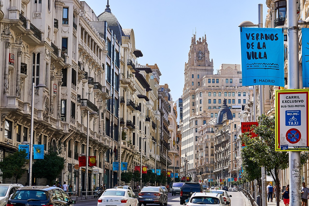 An illustrative photo of a road with cars between buildings in Madrid, Spain