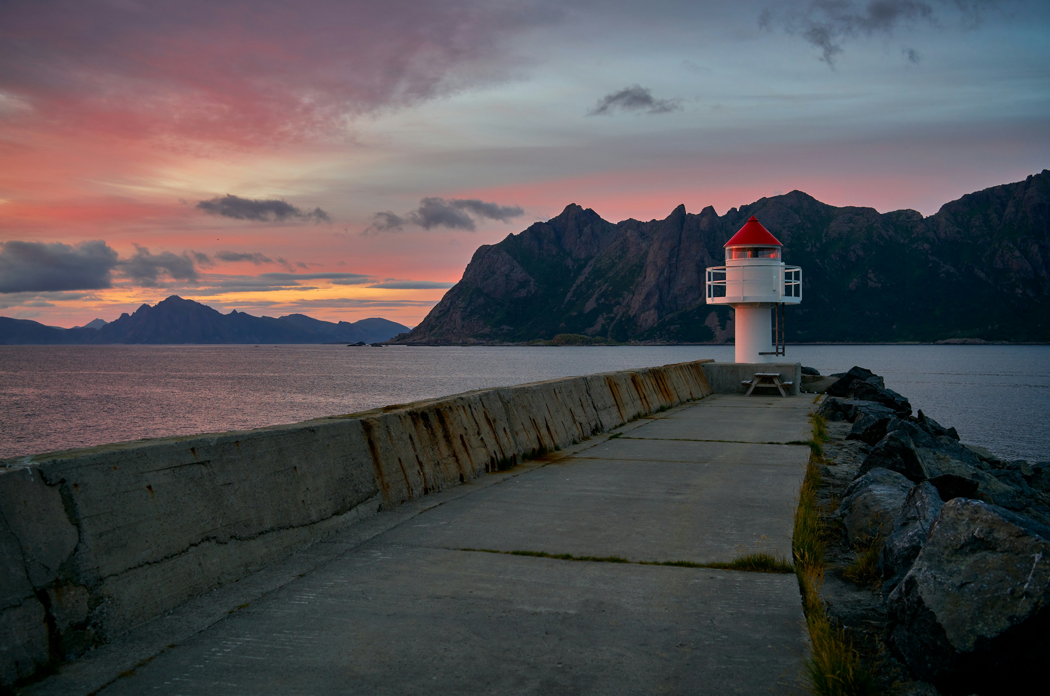 An illustrative photo of a white lighthouse near body of water.