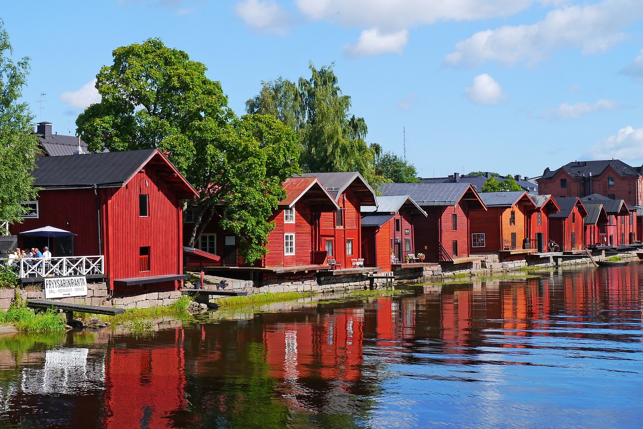 An illustrative photo of red wooden houses near the river