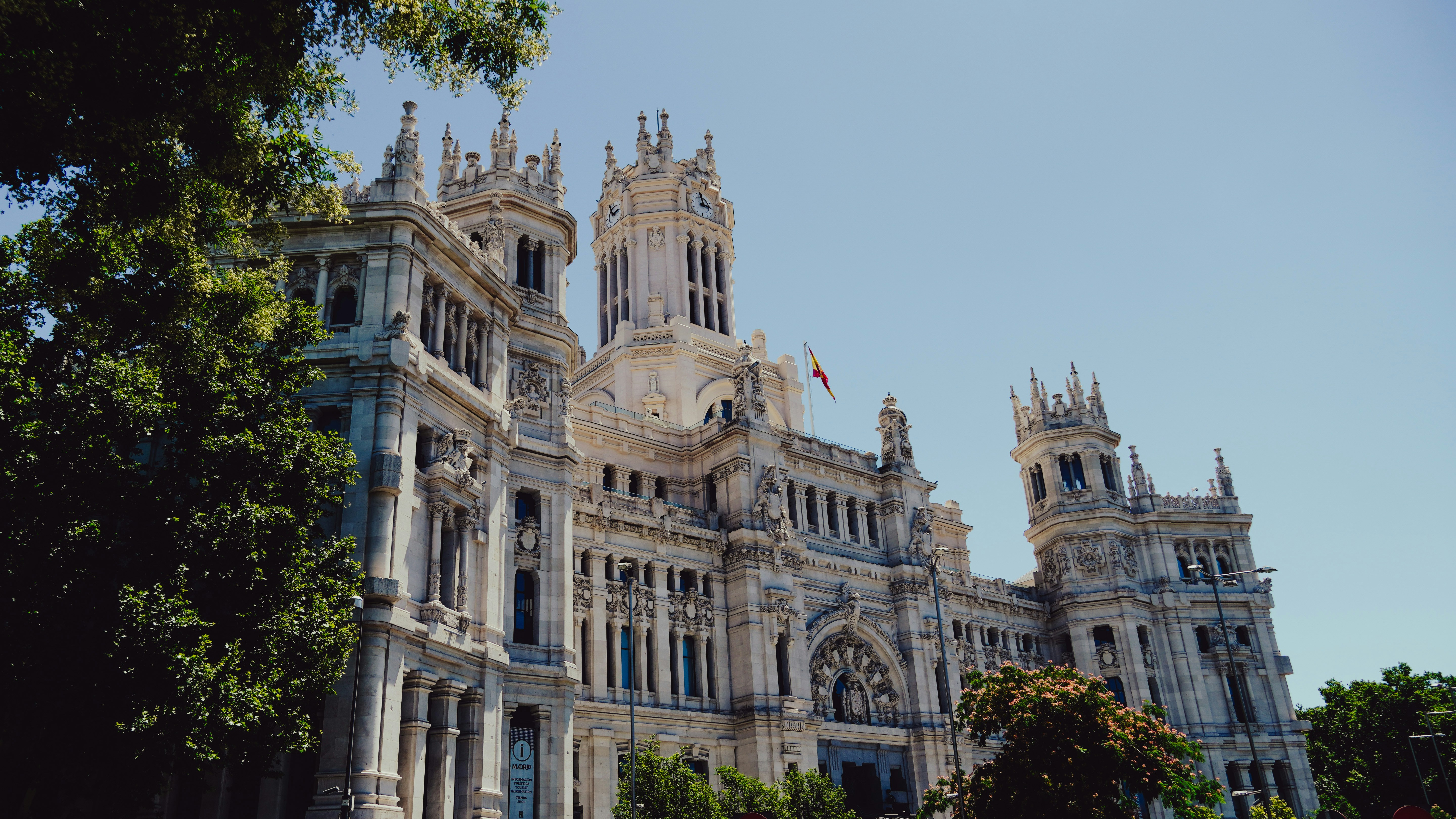 An illustrative photo of a large white building with a clock tower on top of it in Madrid.