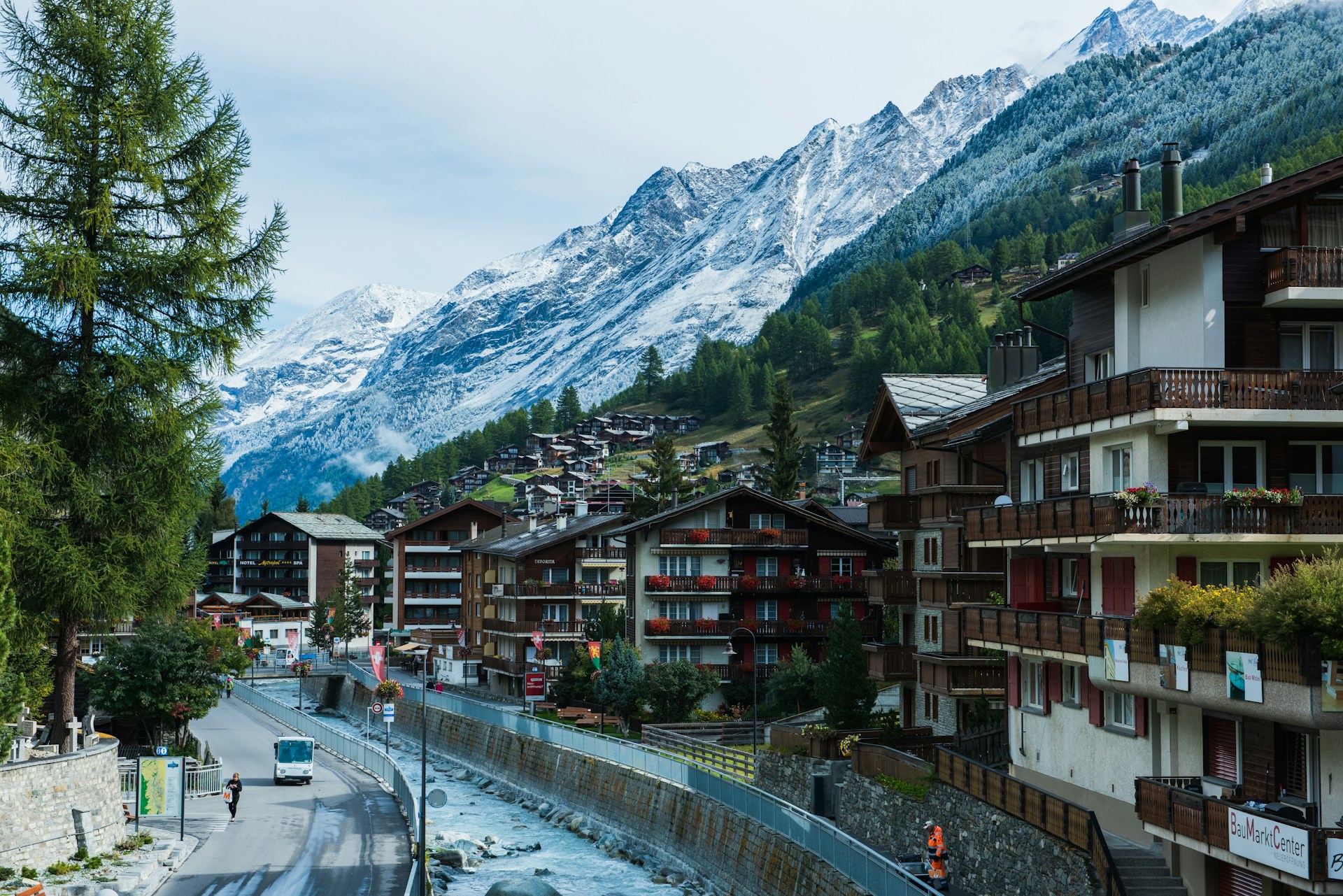 An illustrative photo of houses near a road and mountains under blue sky