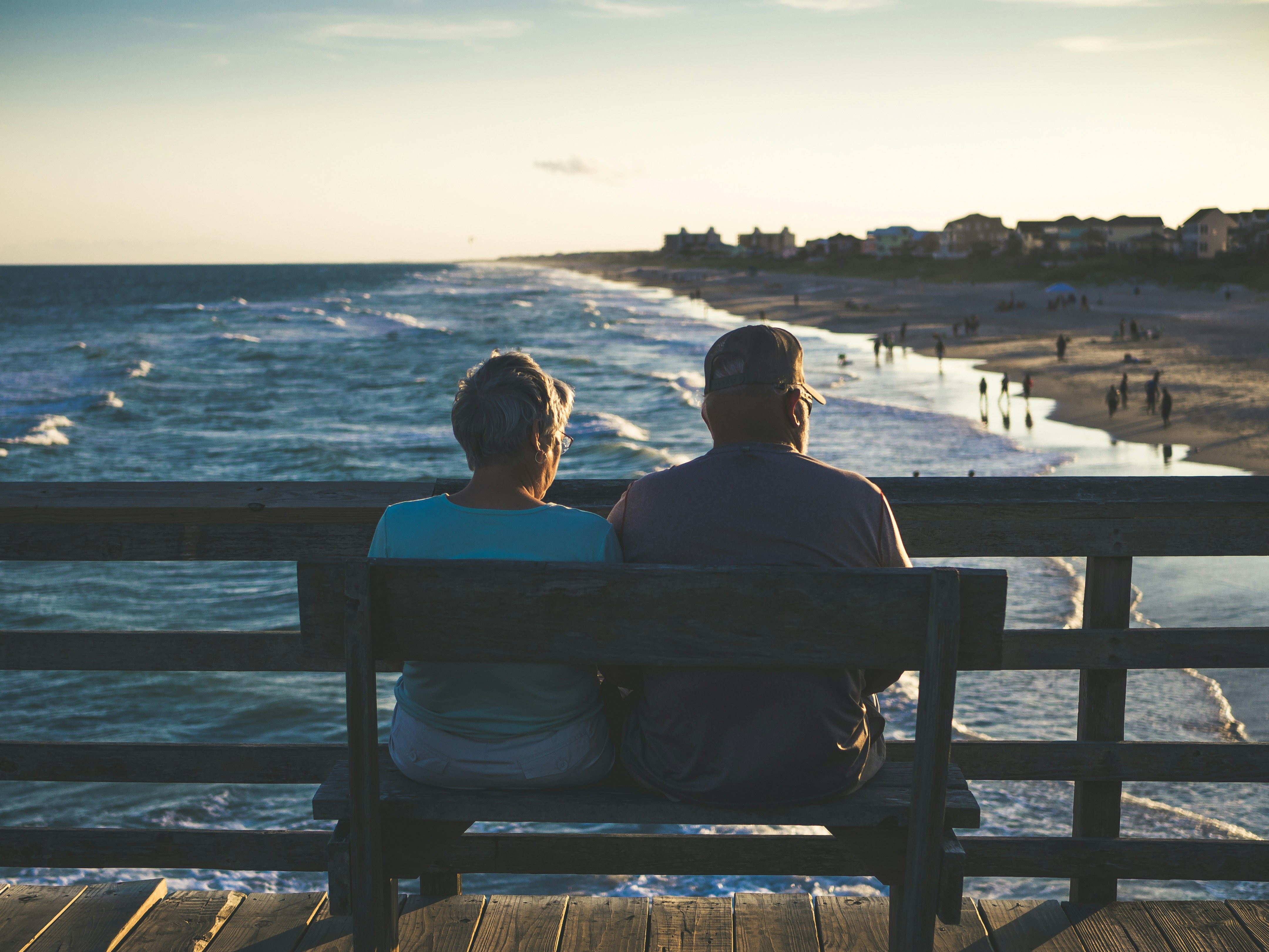Photo by Unsplash An illustrative photo of old man and woman sitting on bench in front of beach