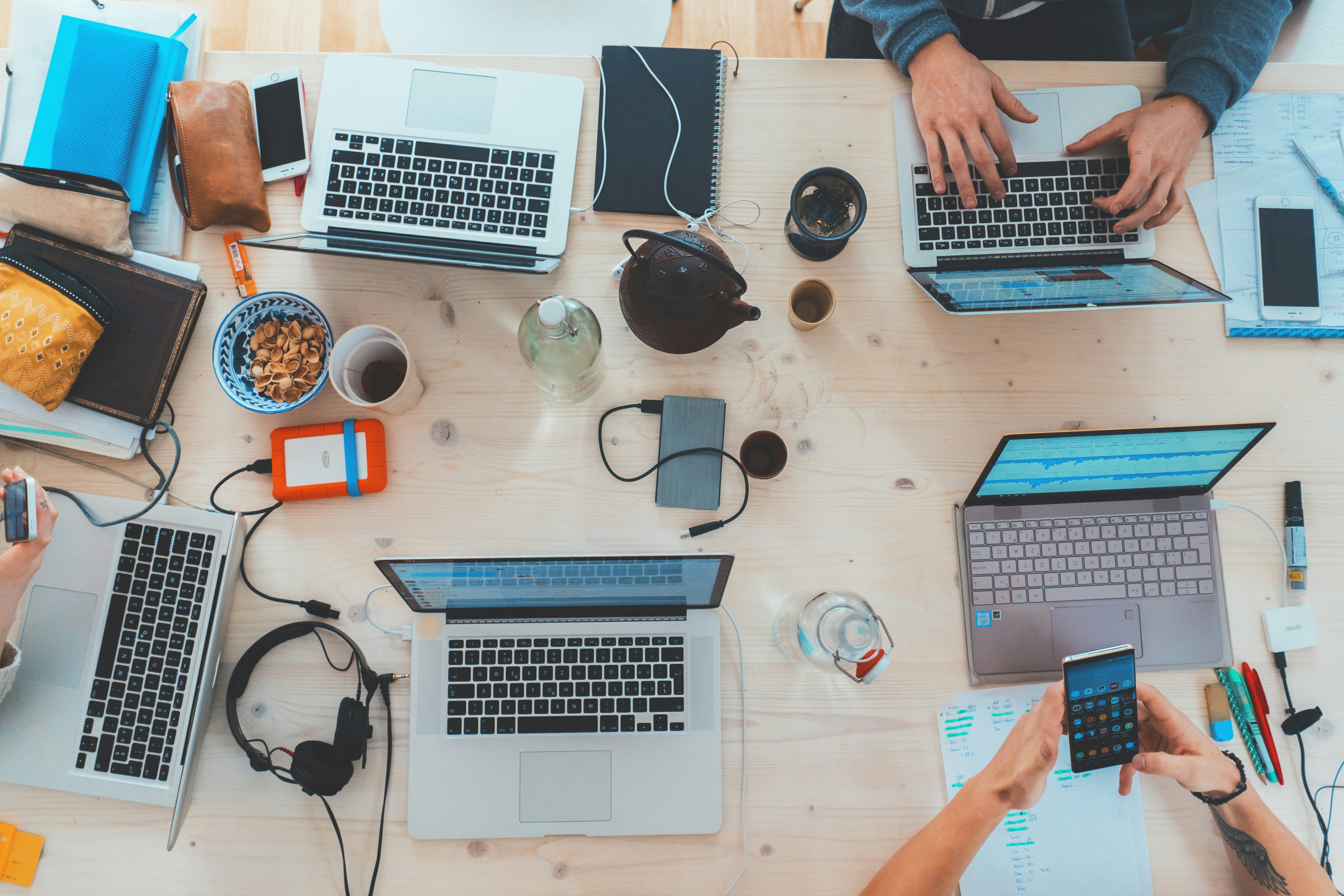 An illustrative photo of people sitting down near table with laptops