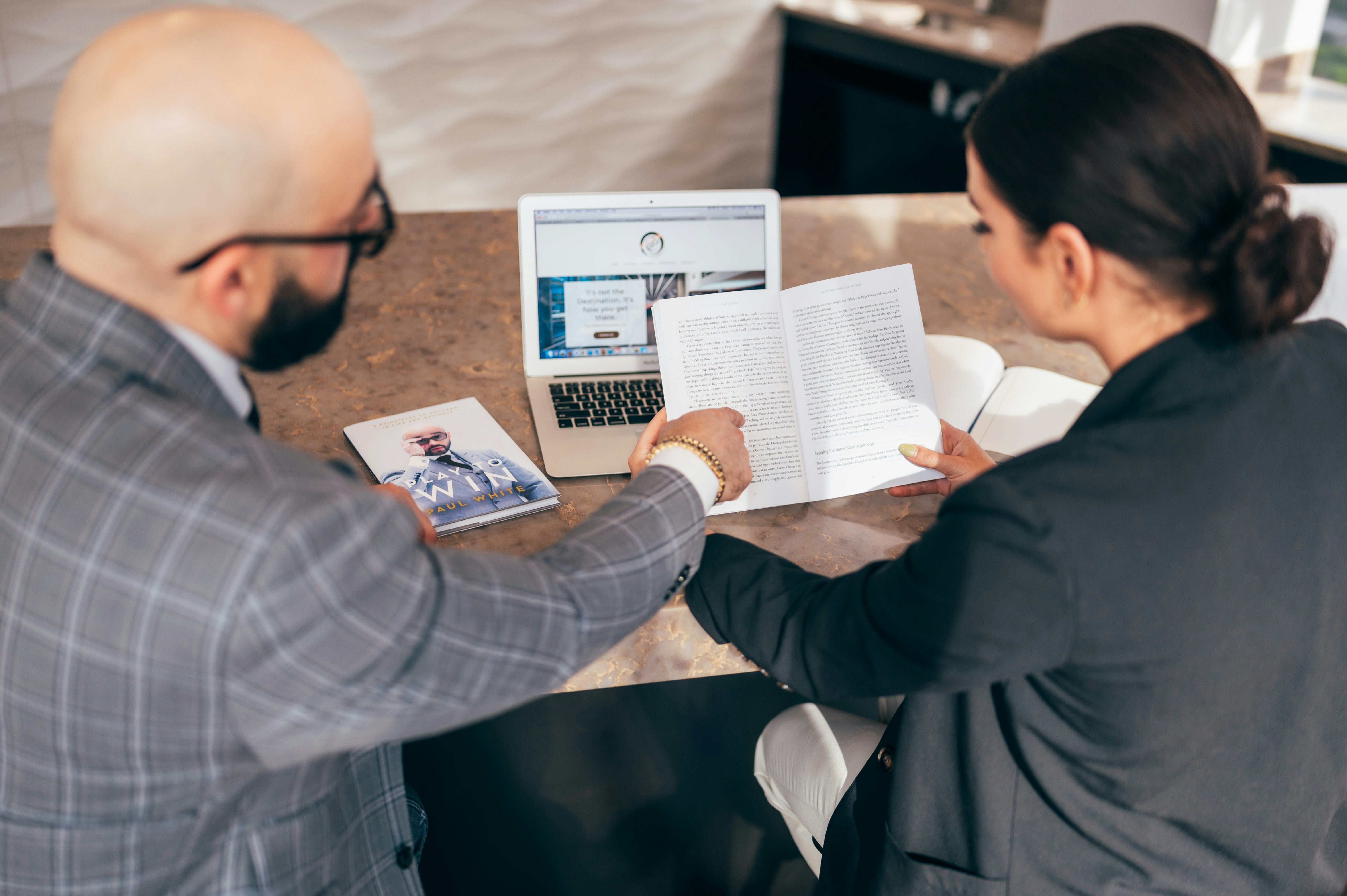 An illustrative photo of two people discussing a paper