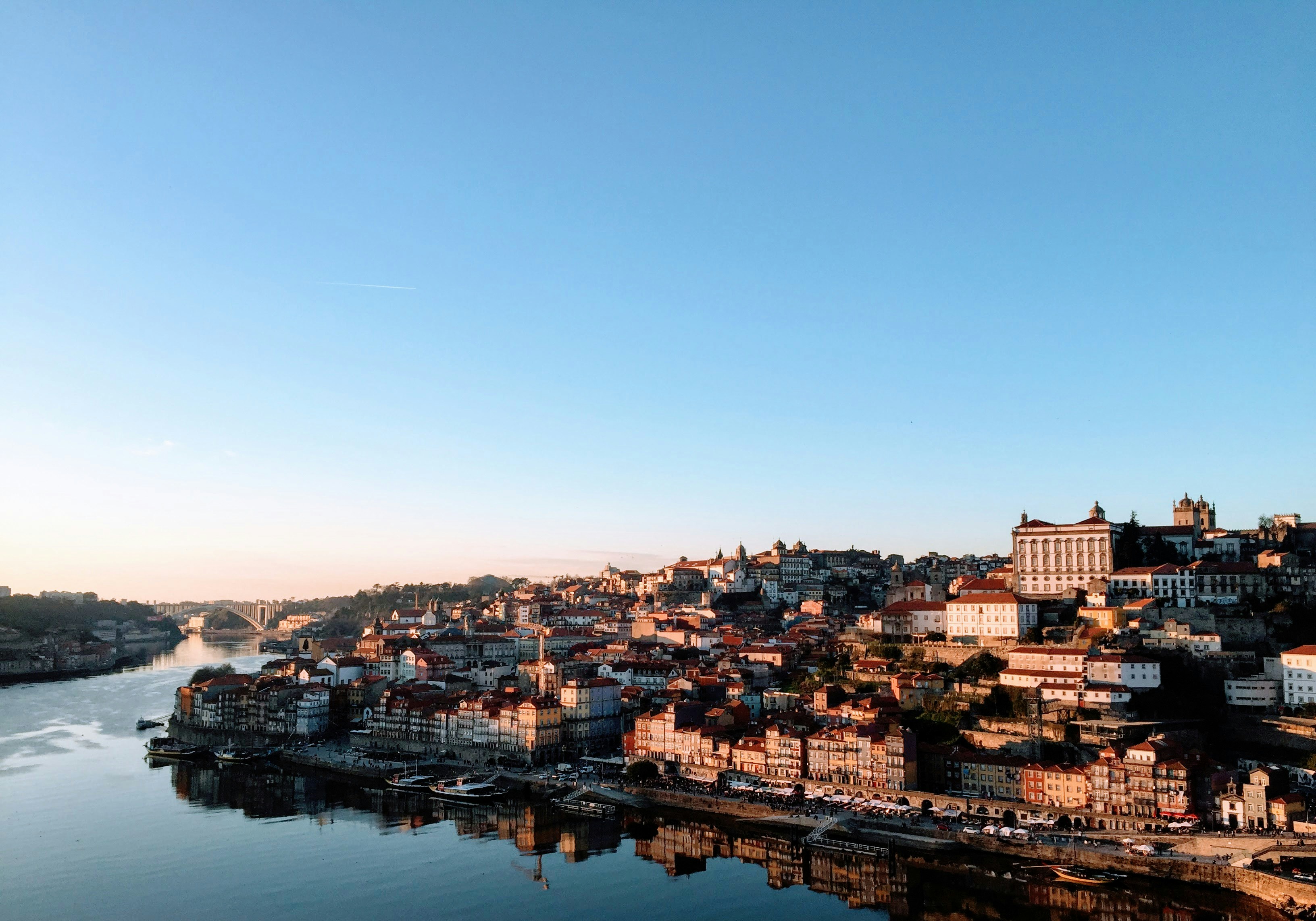 An illustrative photo of city buildings near river under blue sky