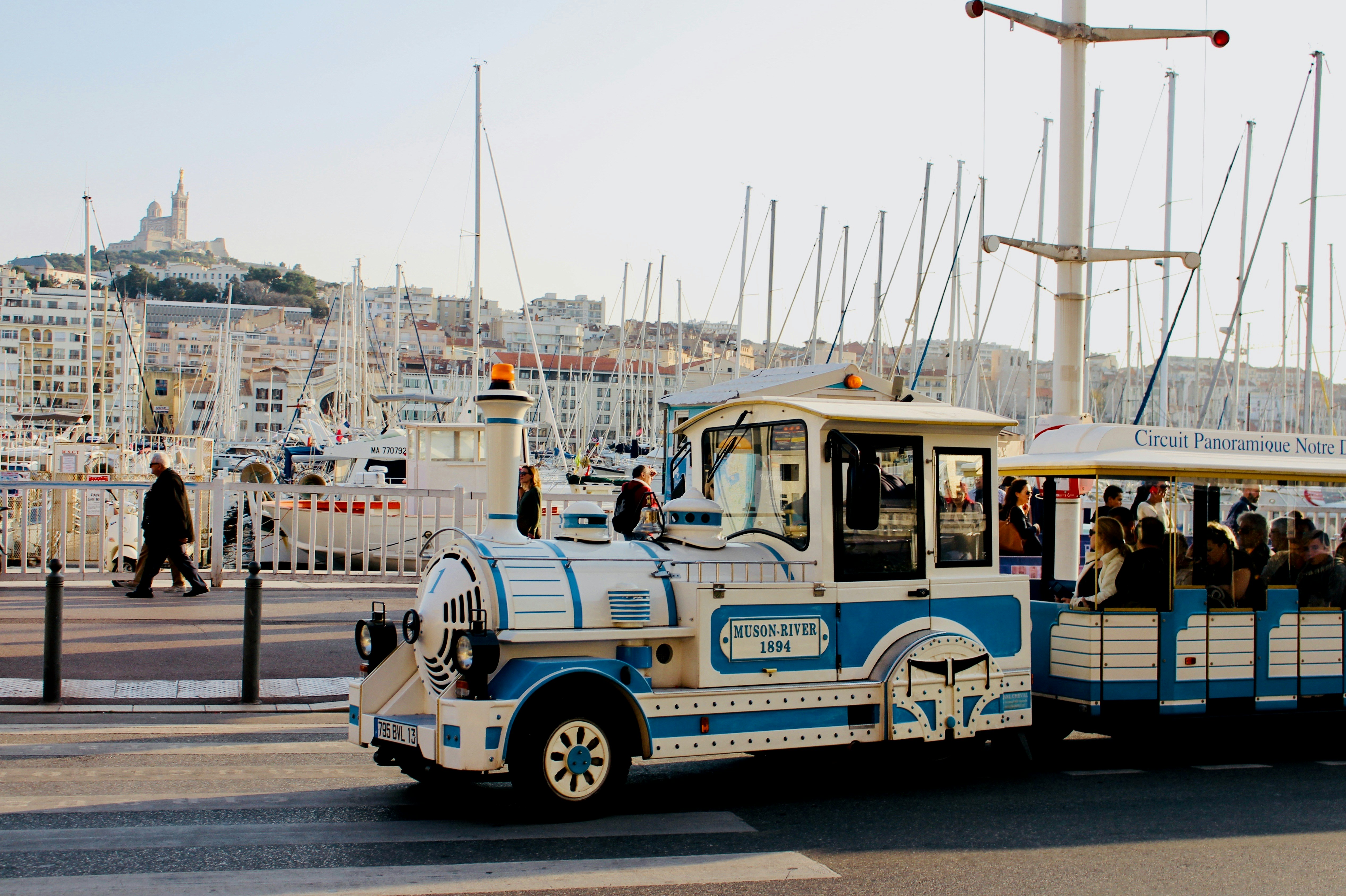 Photo by Unsplash An illustrative photo of white and blue tourist train on the road